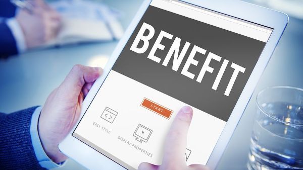 A person is holding a tablet with the word benefit on it.