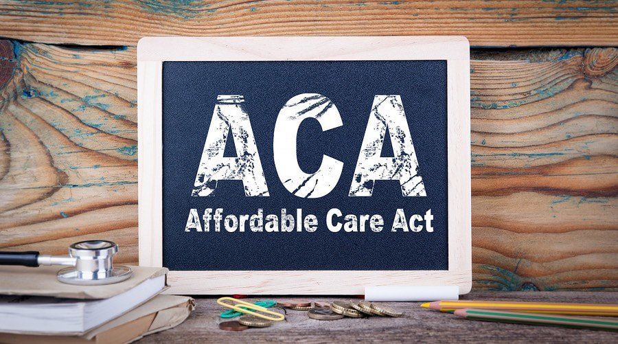 a chalkboard with the words ACA affordable care act written on it