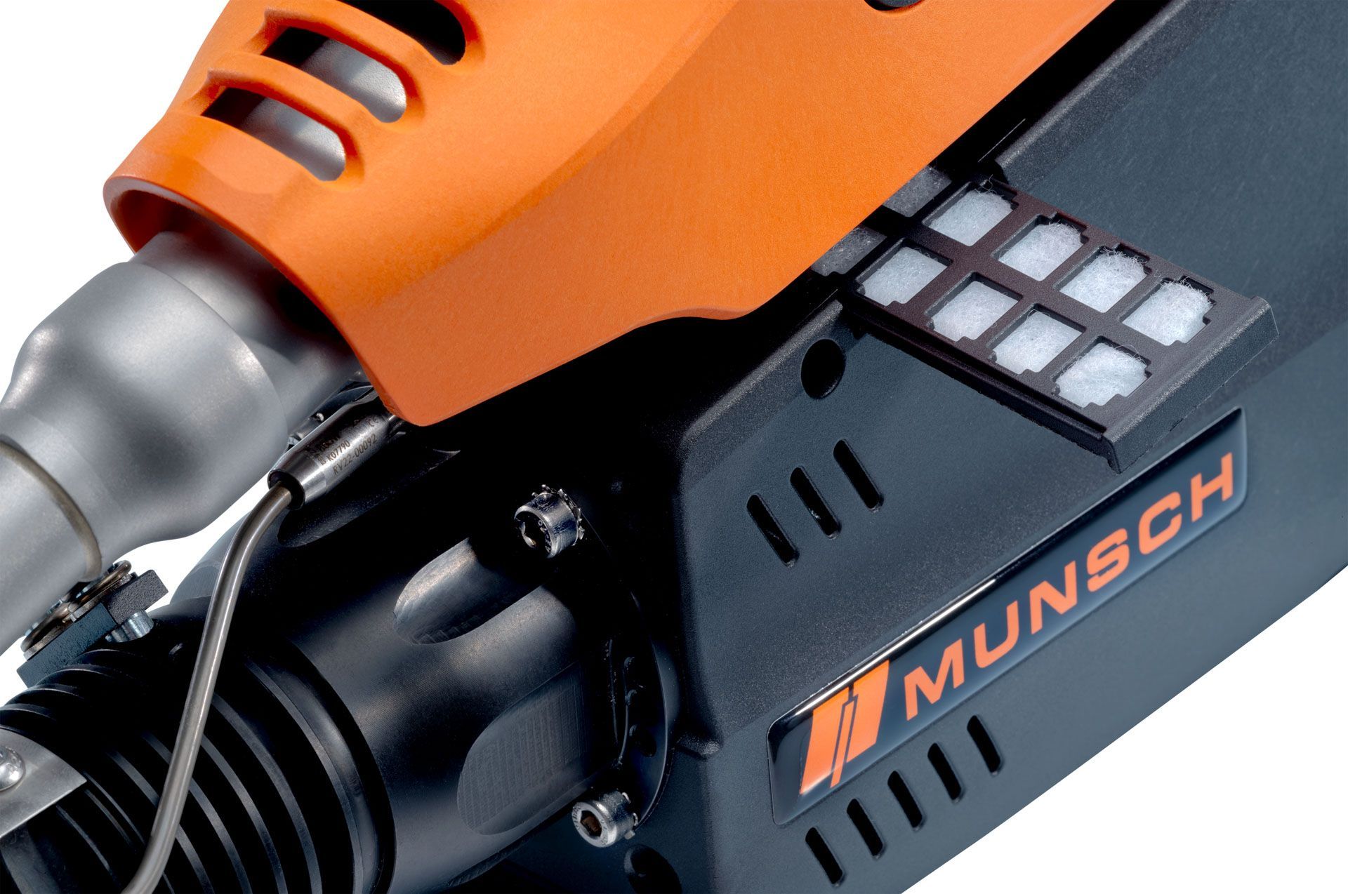 Primer plano de una máquina de soldar Munsch negra y naranja, que muestra un filtro y rejillas de ventilación.