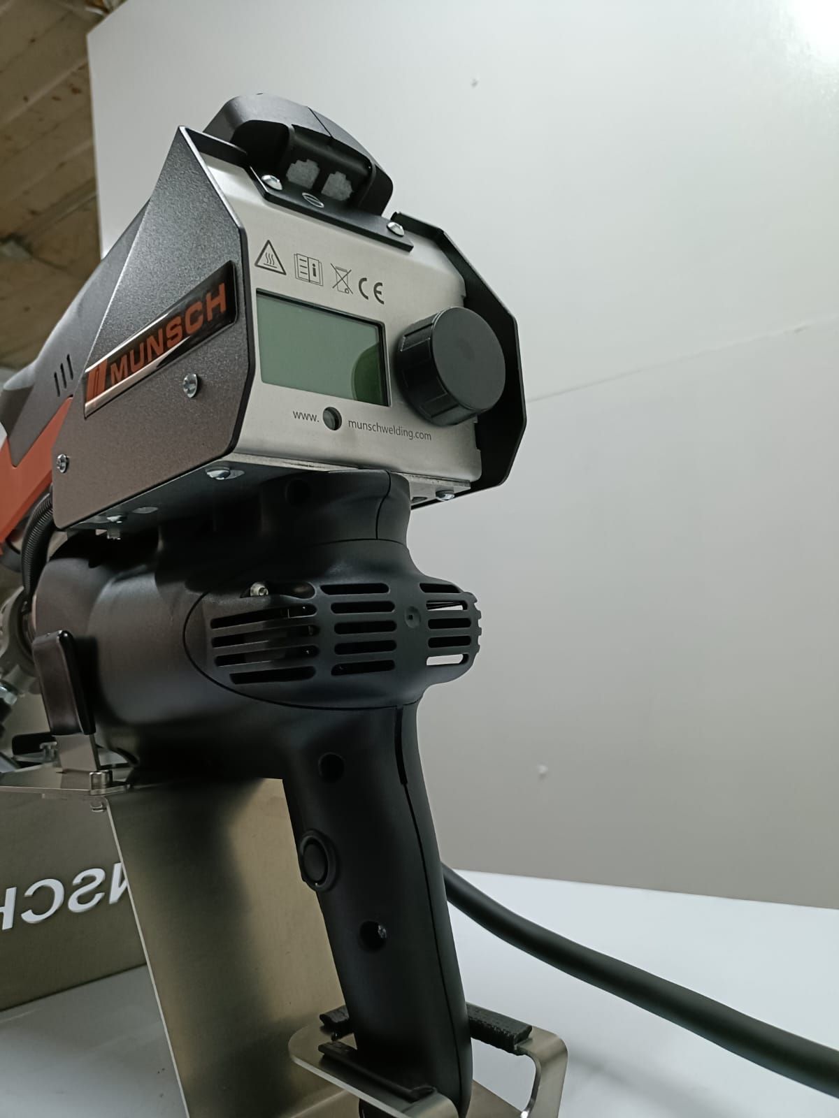 Máquina de soldar plástico portátil de color negro y naranja con pantalla digital y perilla de ajuste.