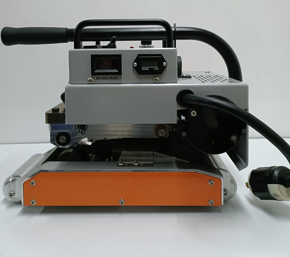 Máquina selladora térmica industrial plateada y naranja con mango, cable de alimentación y pantalla digital.