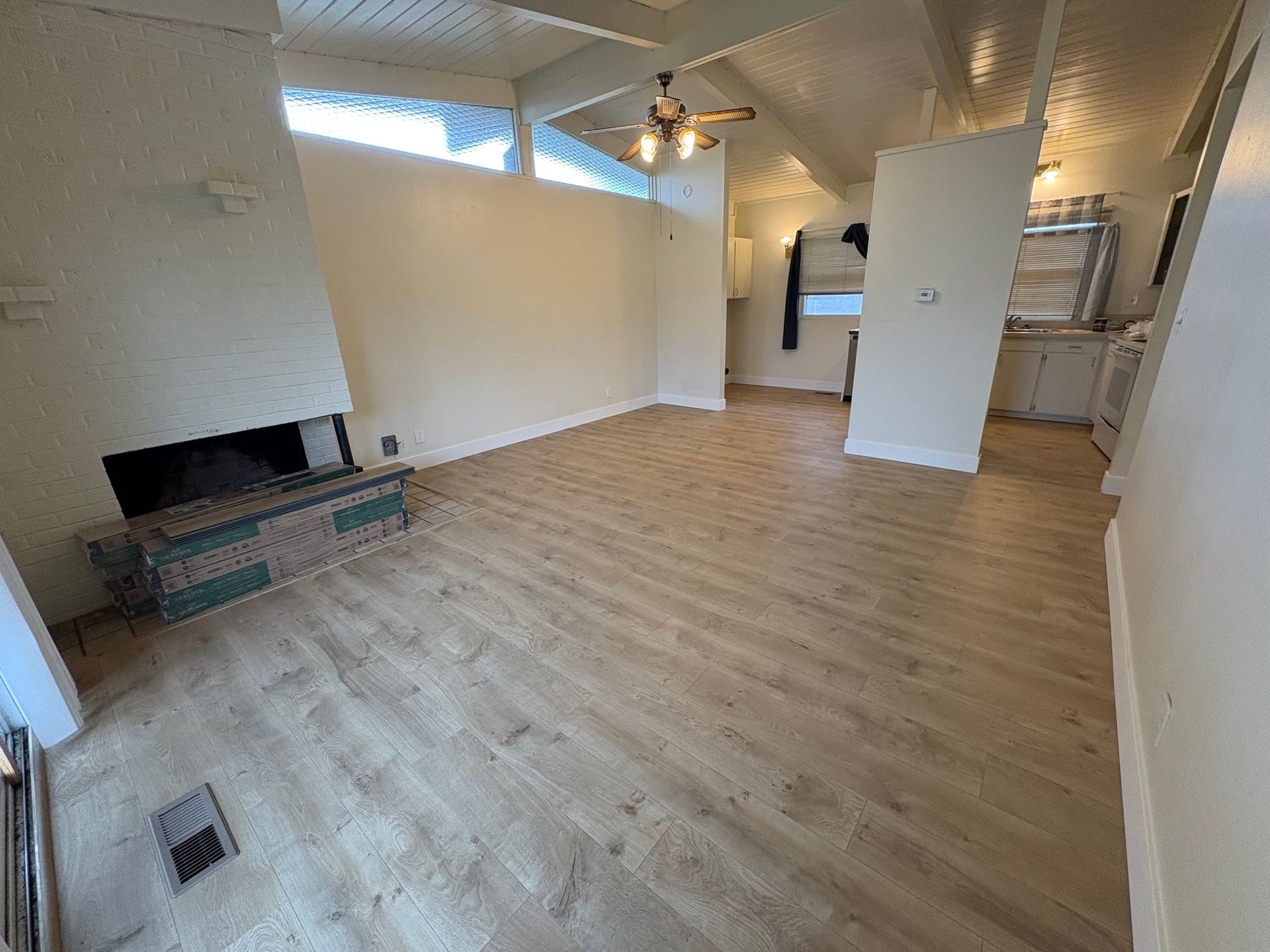 A living room with hardwood floors and a fireplace.