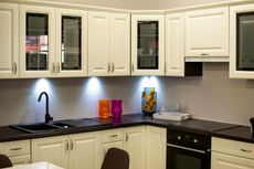 A kitchen with white cabinets and black counter tops