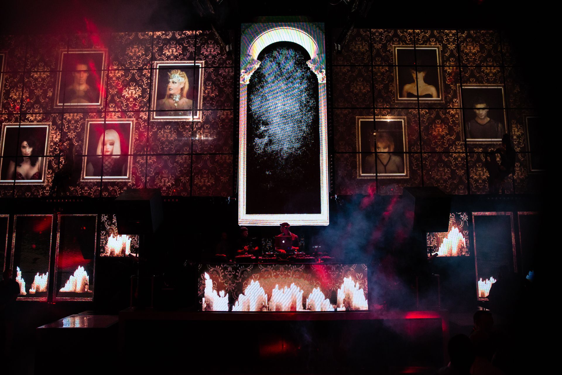 A man is standing in front of a wall with pictures on it.