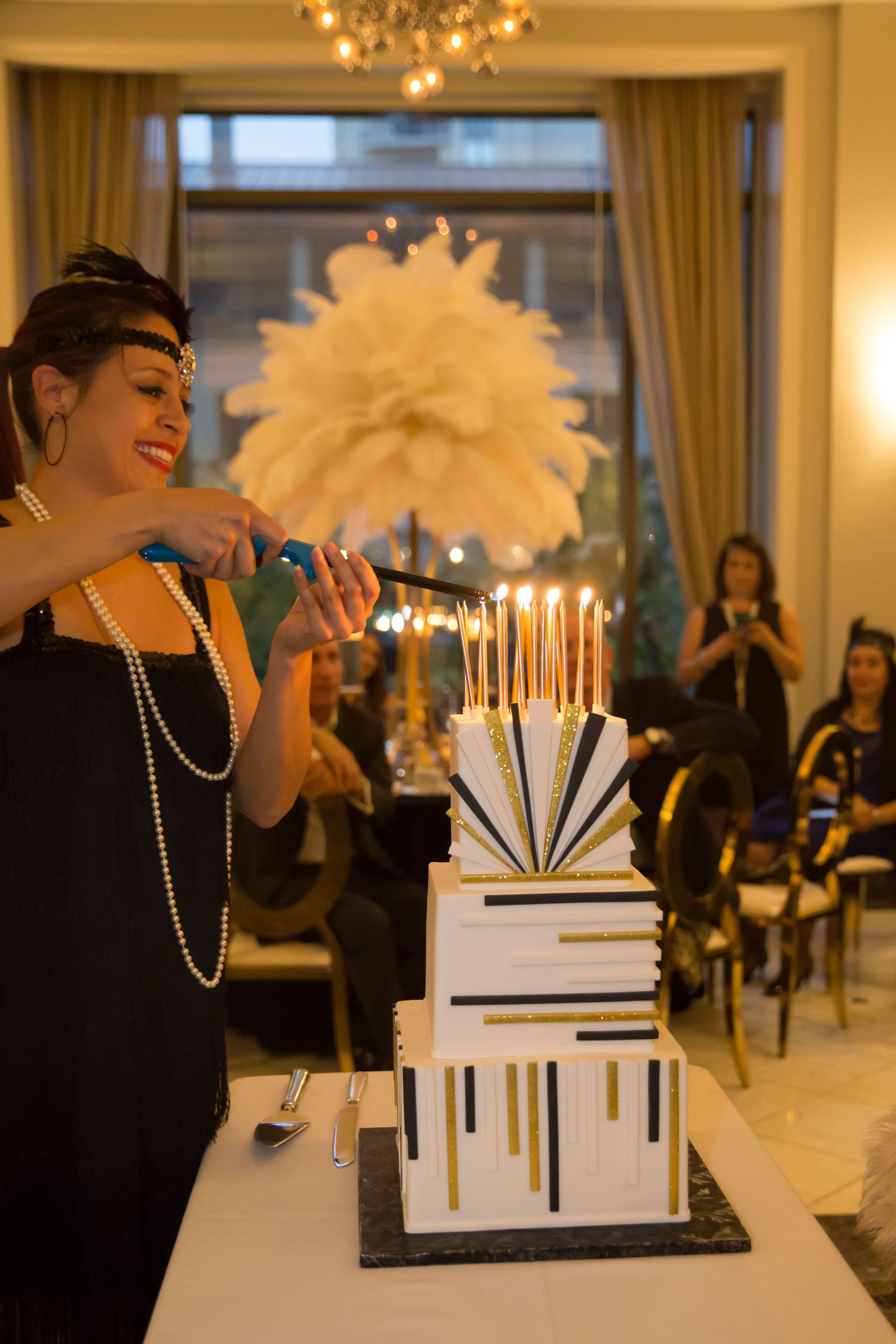 A woman is cutting a cake with candles on it.
