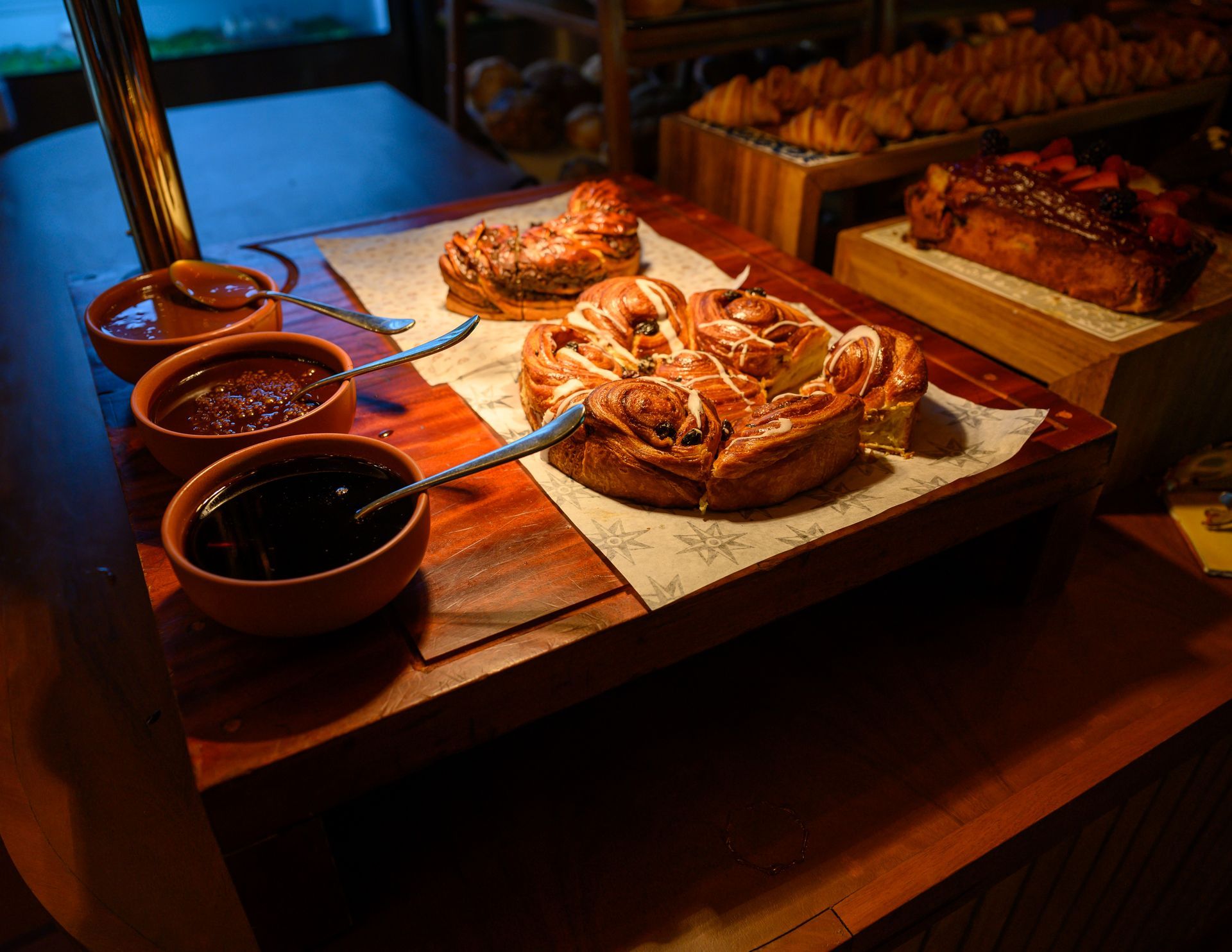 A wooden table topped with a variety of pastries and sauces.