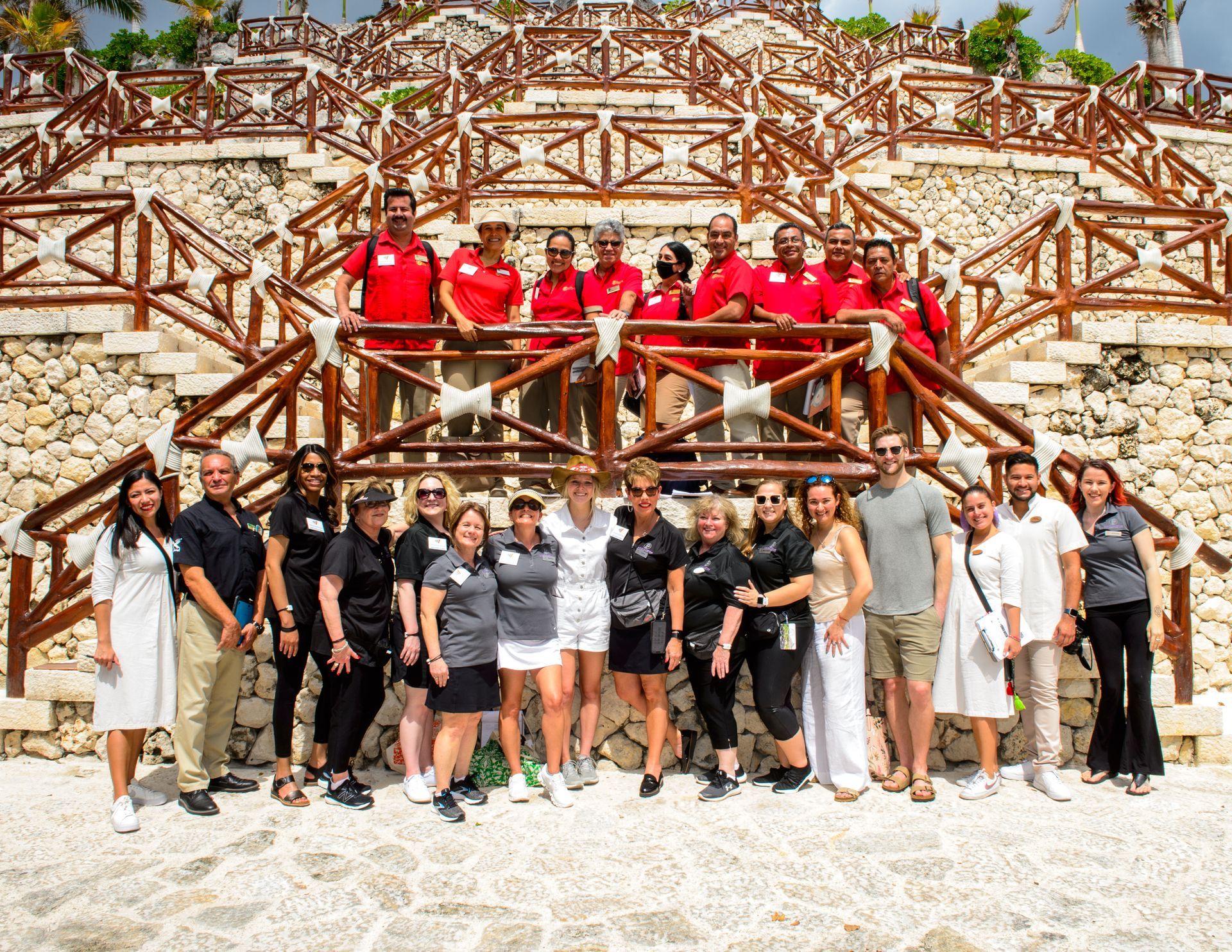 A group of people are posing for a picture in front of stairs.