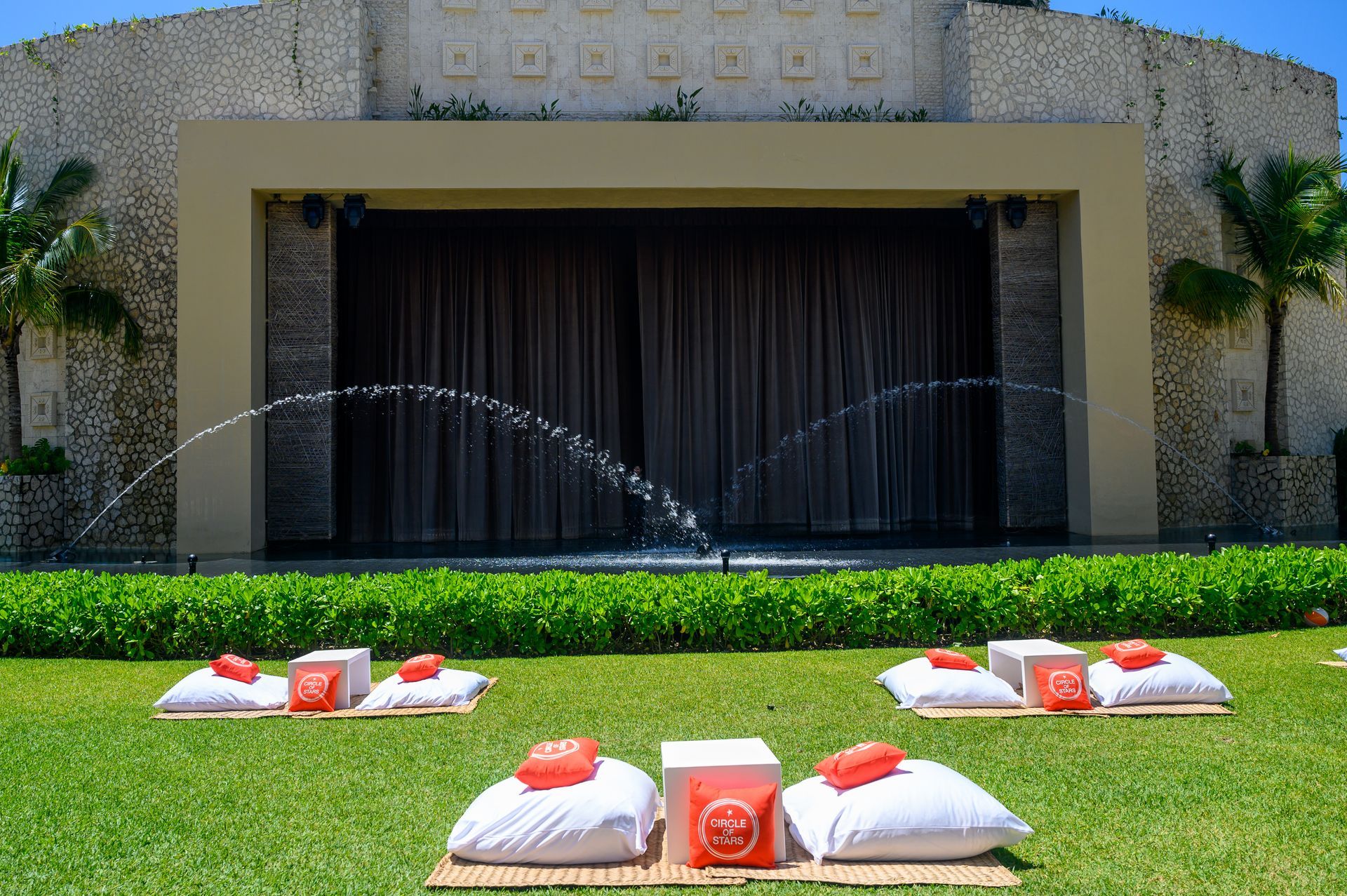 A large building with a stage and a fountain in front of it.