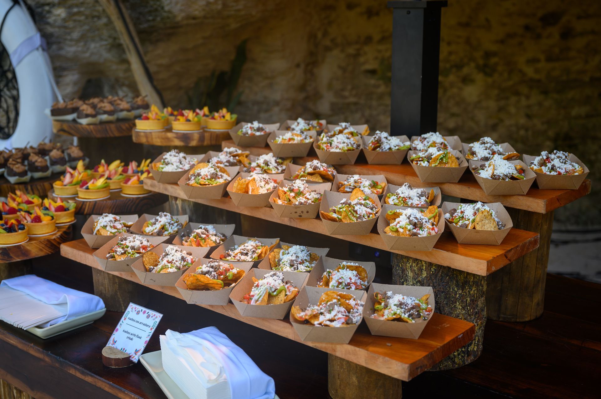 A display of food in cardboard containers on wooden shelves.