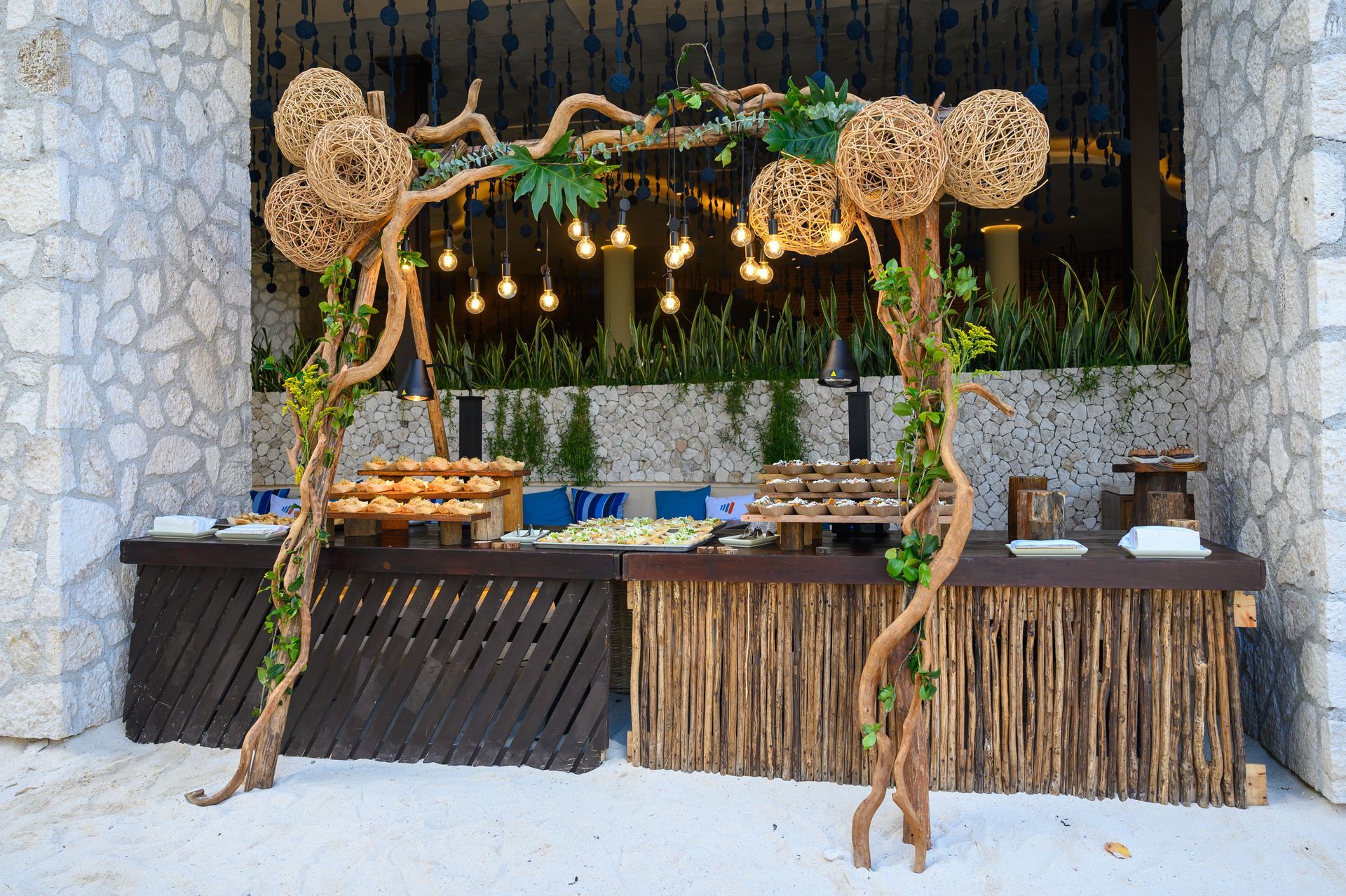 A wooden buffet table is decorated with branches and leaves.
