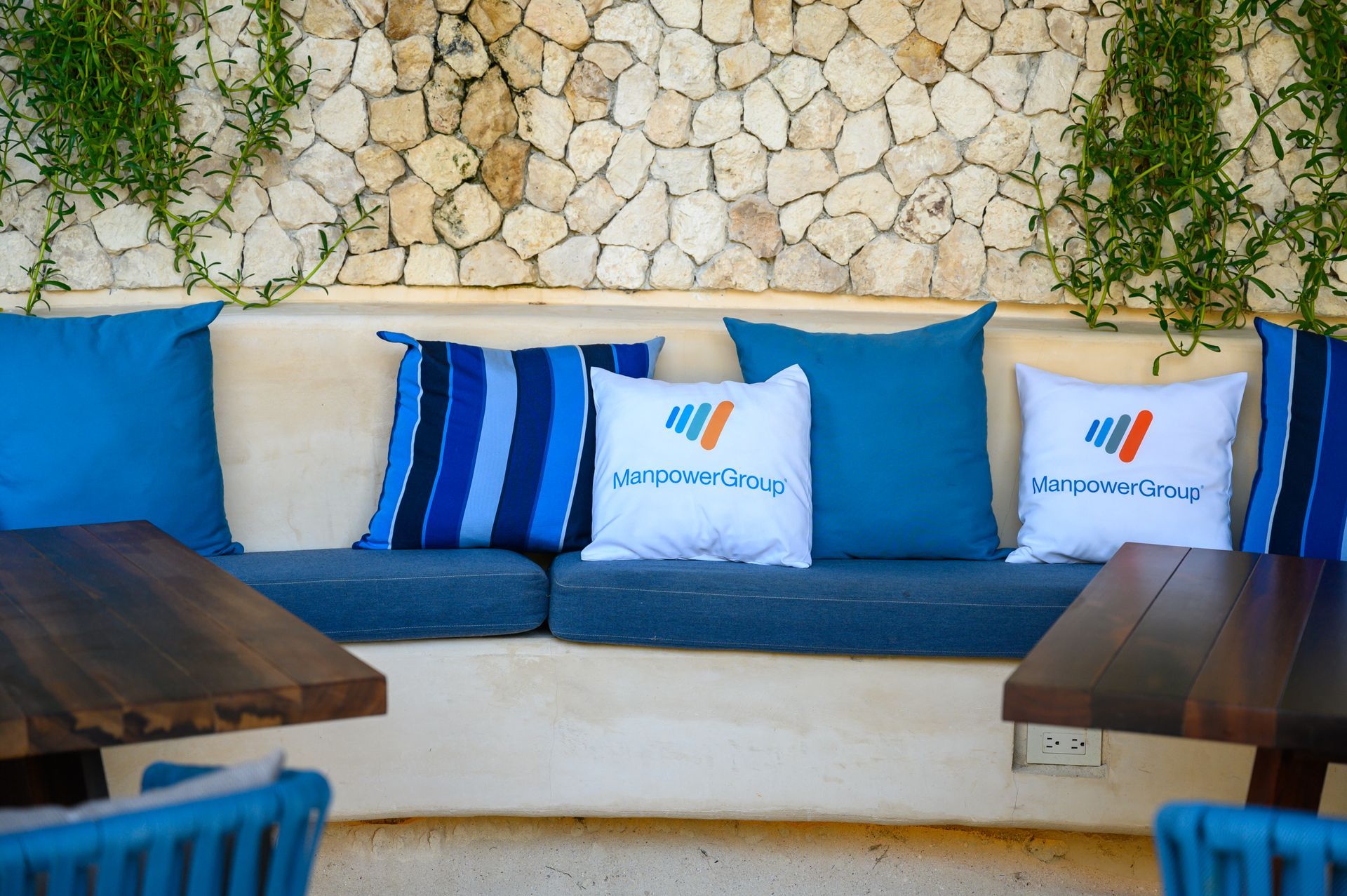 A couch with blue cushions and white pillows with the word air on them