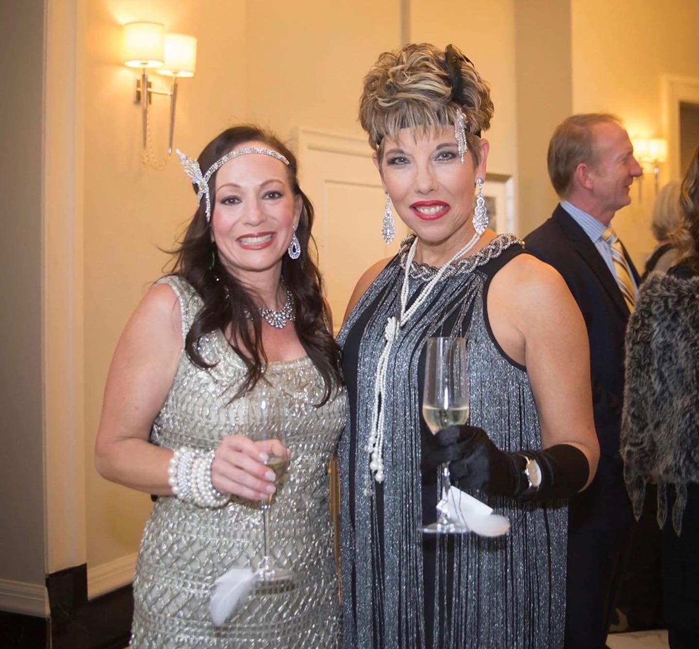 Two women standing next to each other holding wine glasses