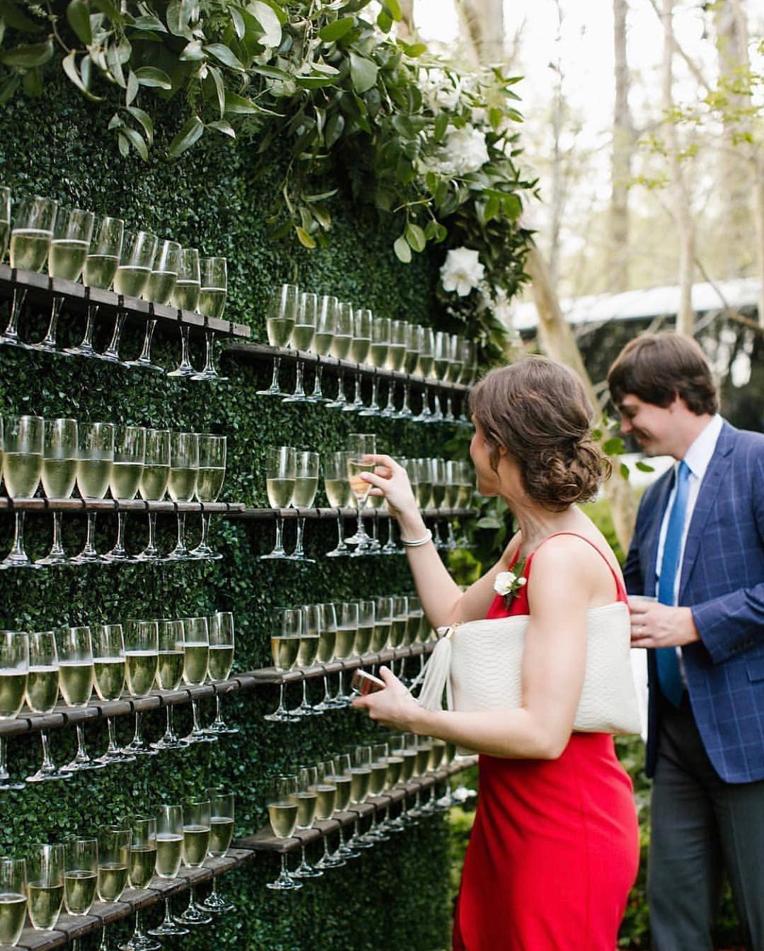Couple stand in front of champagne wall
