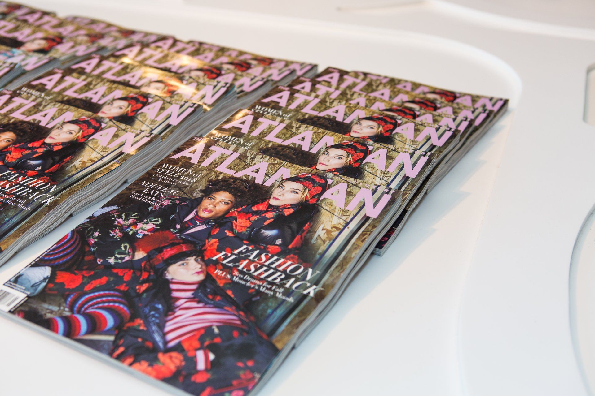 A stack of fashion flashback magazines on a table