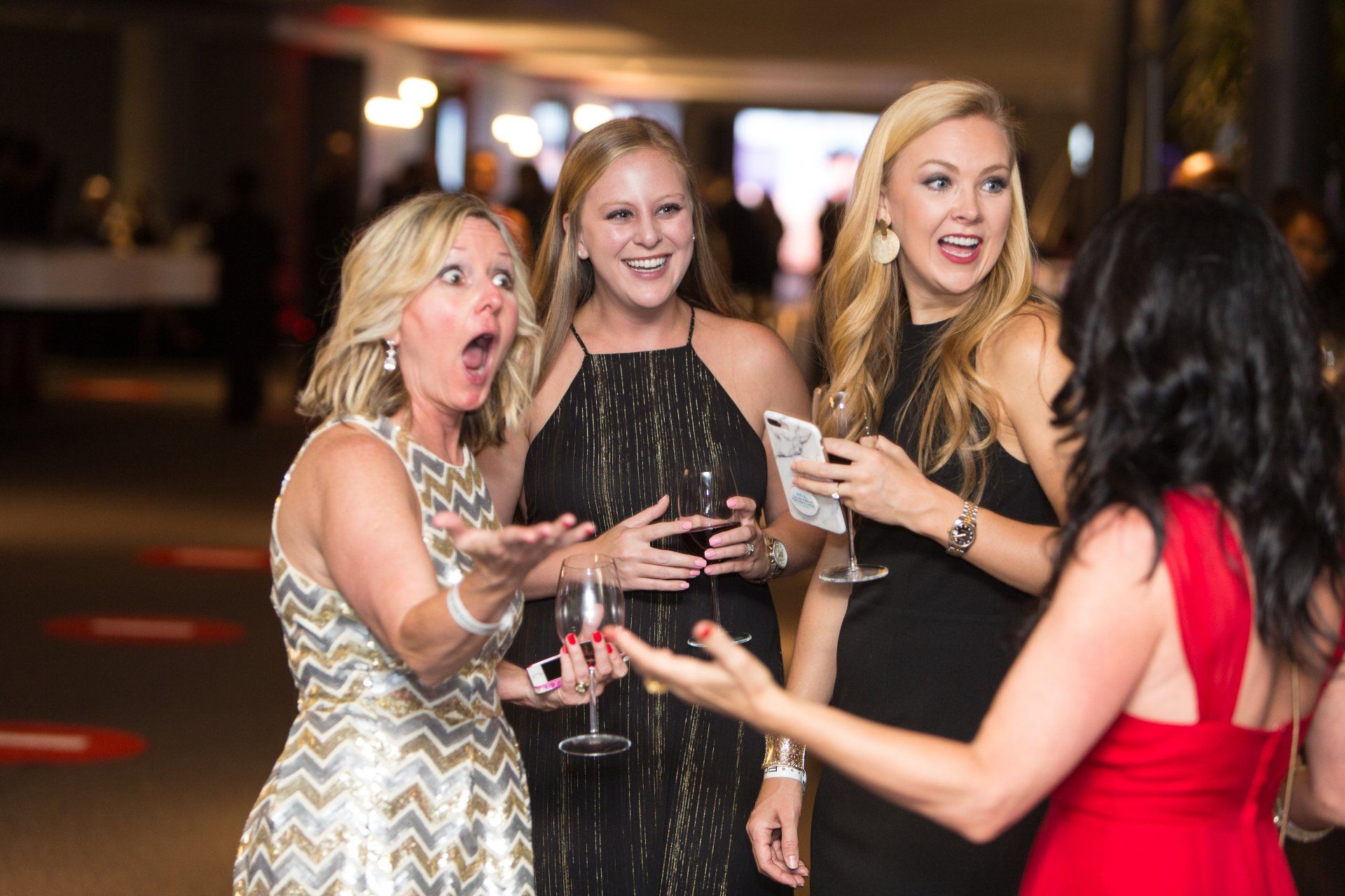 A group of women are standing next to each other at a party.