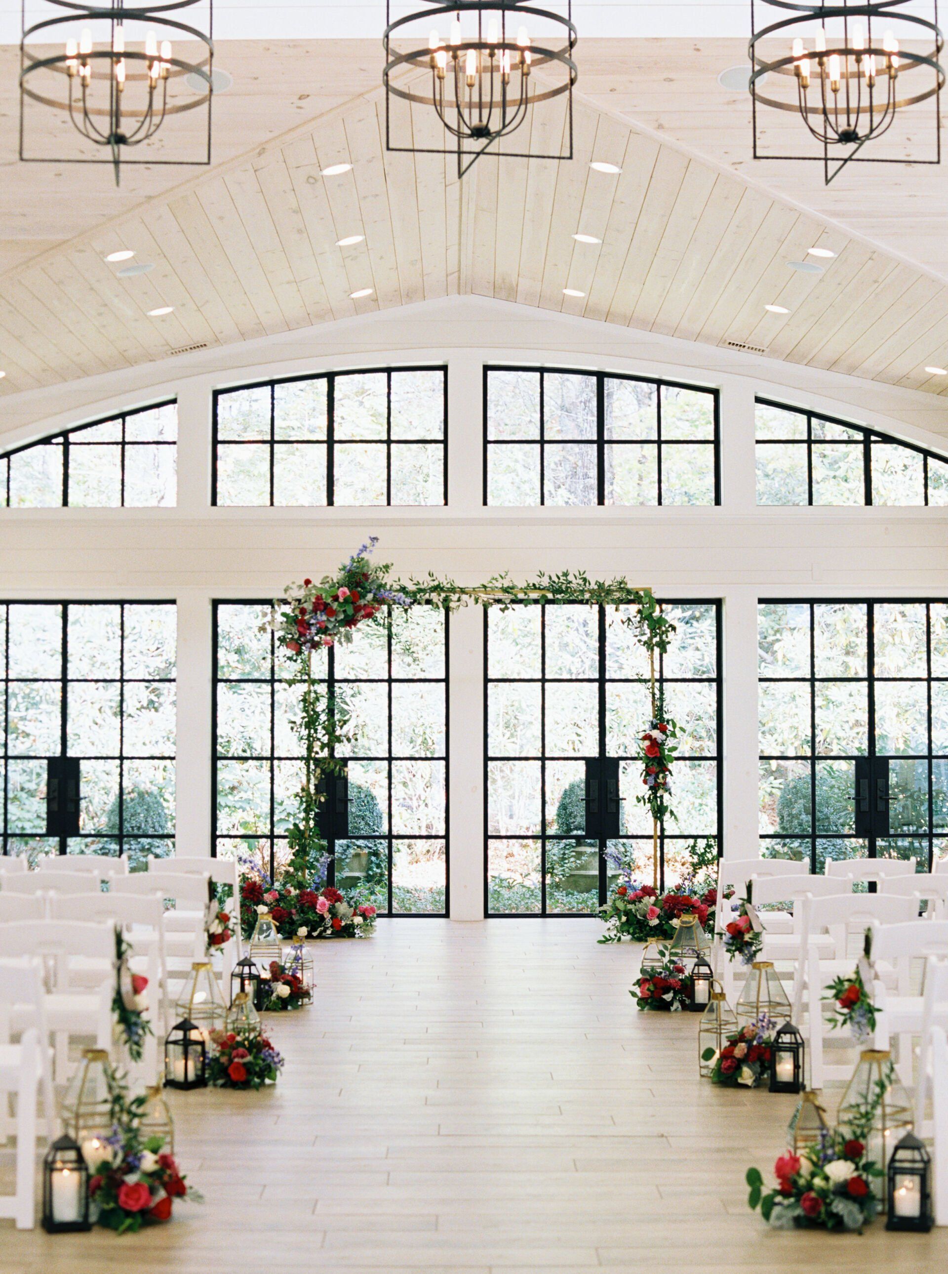 A large room with a lot of windows and flowers on the floor.