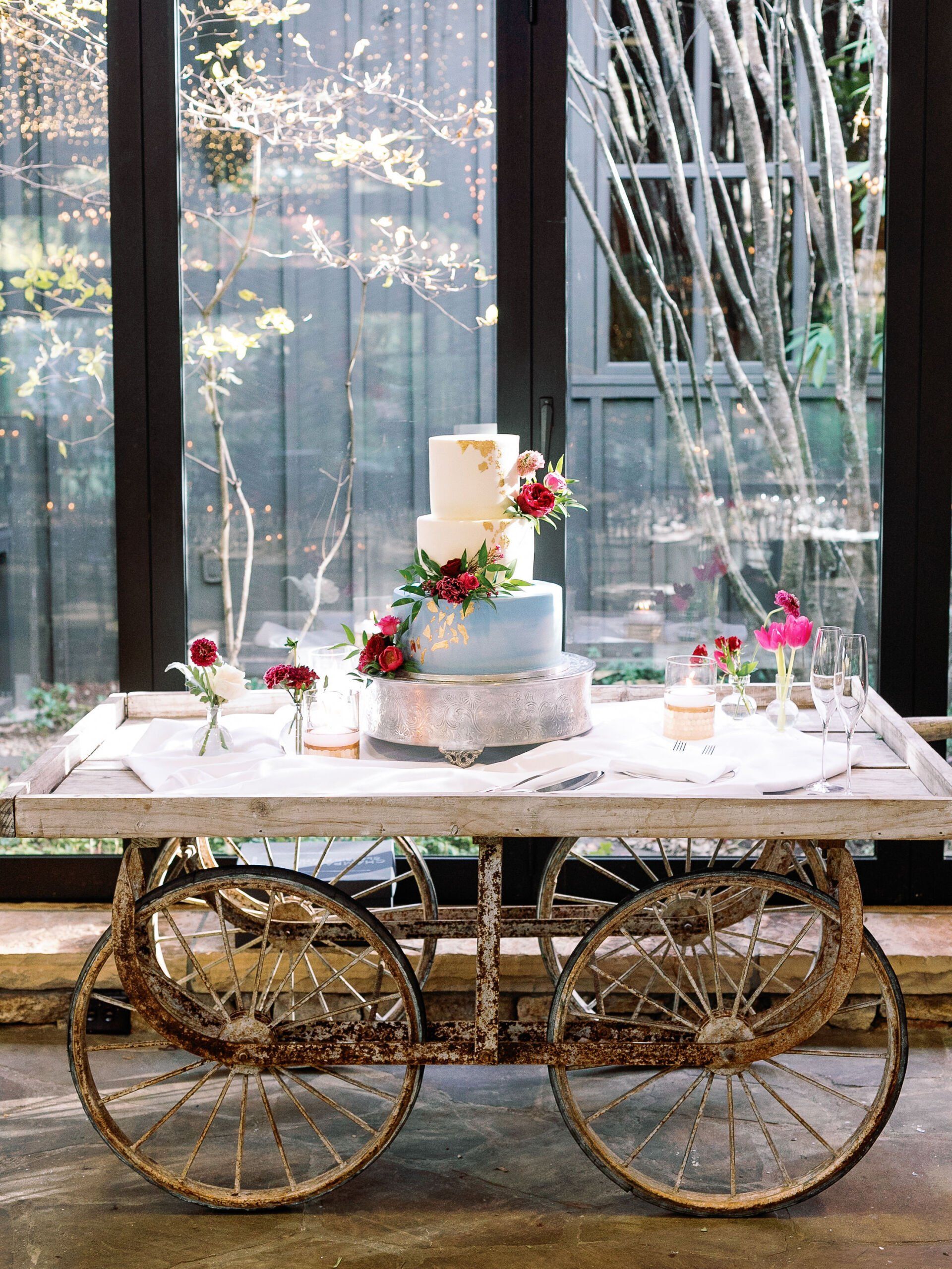 A wedding cake is sitting on top of a wooden cart.