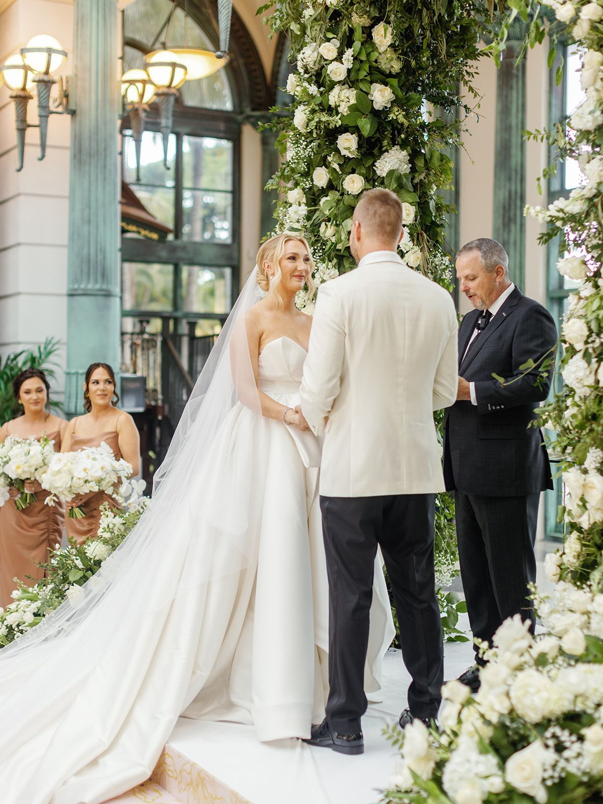 A bride and groom are holding hands during their wedding ceremony.