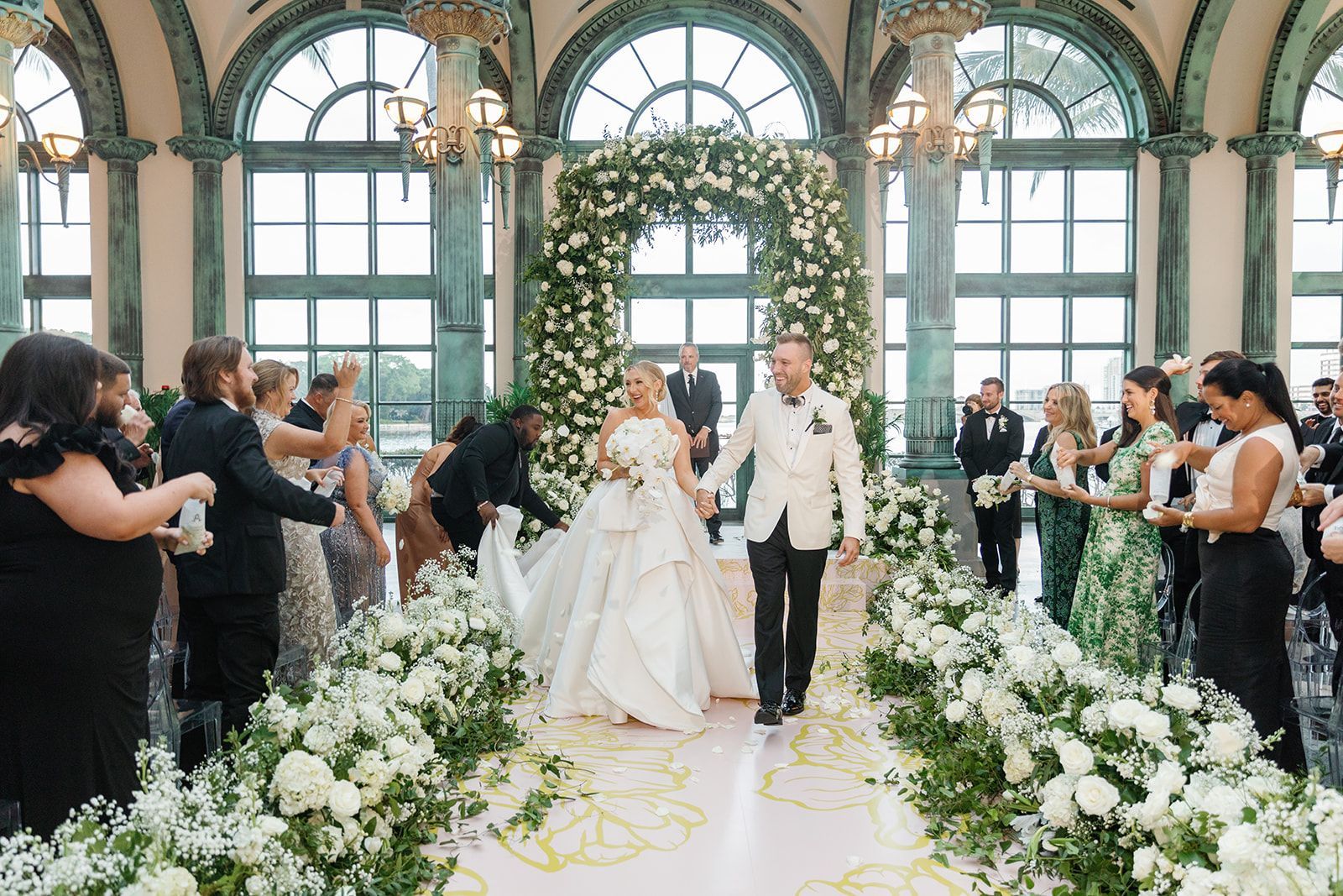 A bride and groom are walking down the aisle at their wedding.