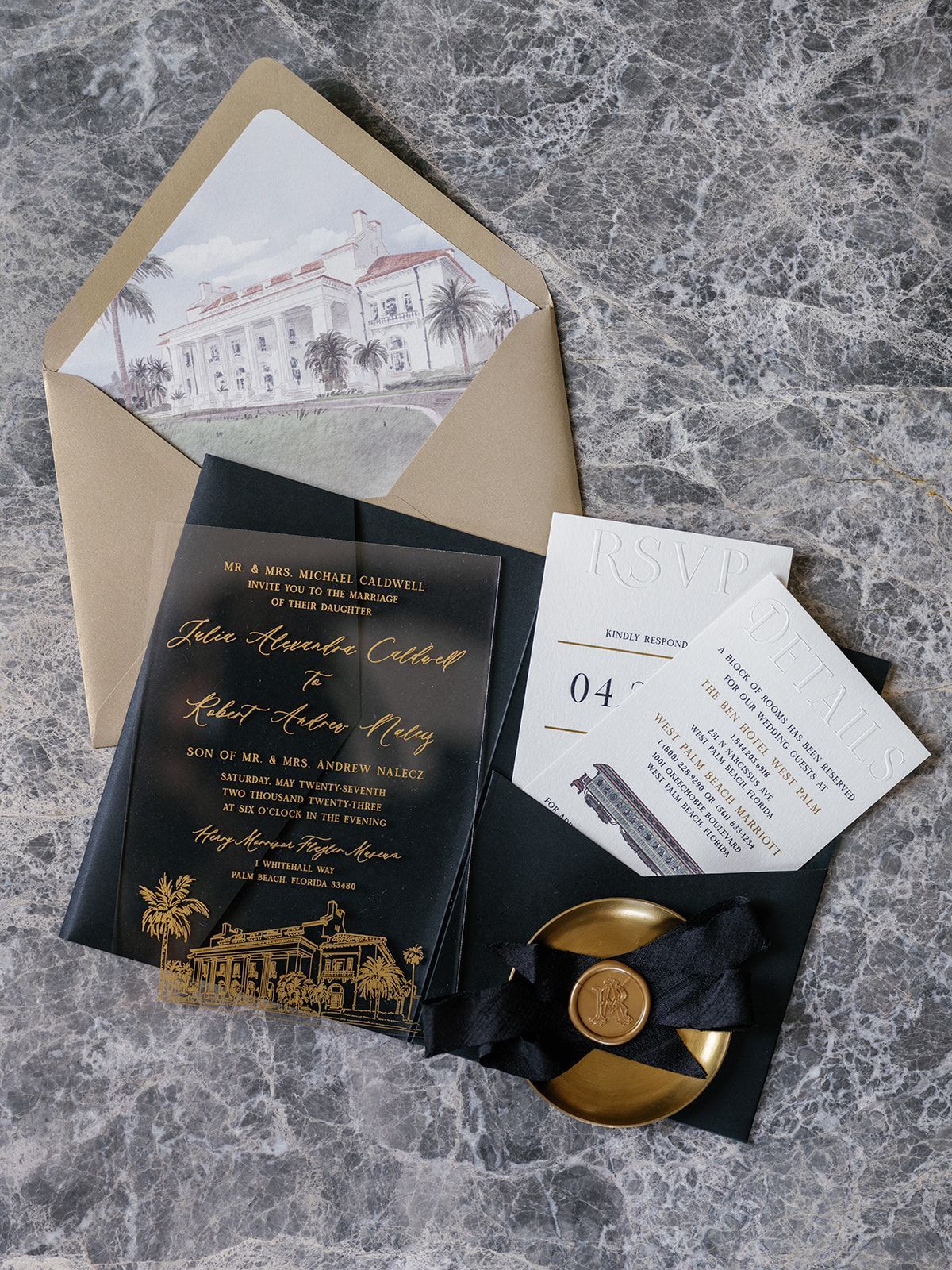 A black and gold wedding invitation is sitting in an envelope on a table.