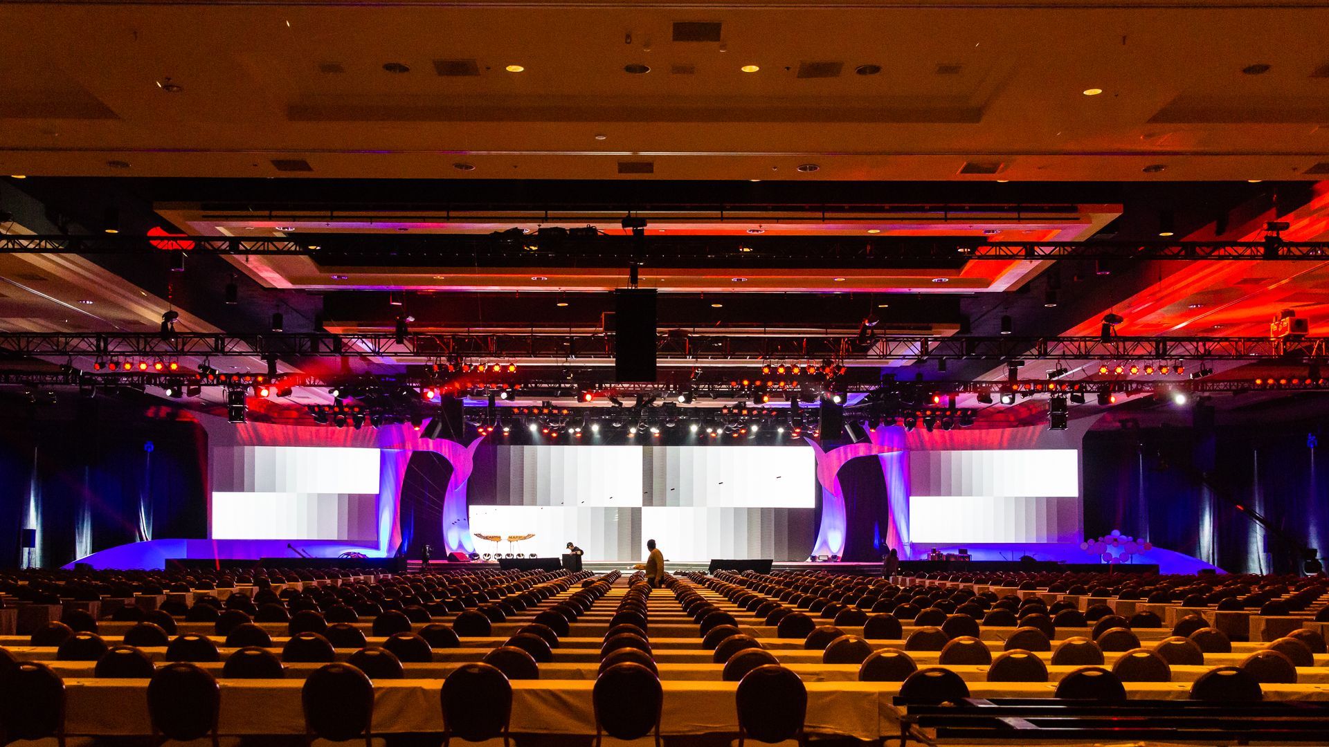 A large auditorium with rows of chairs and a stage.