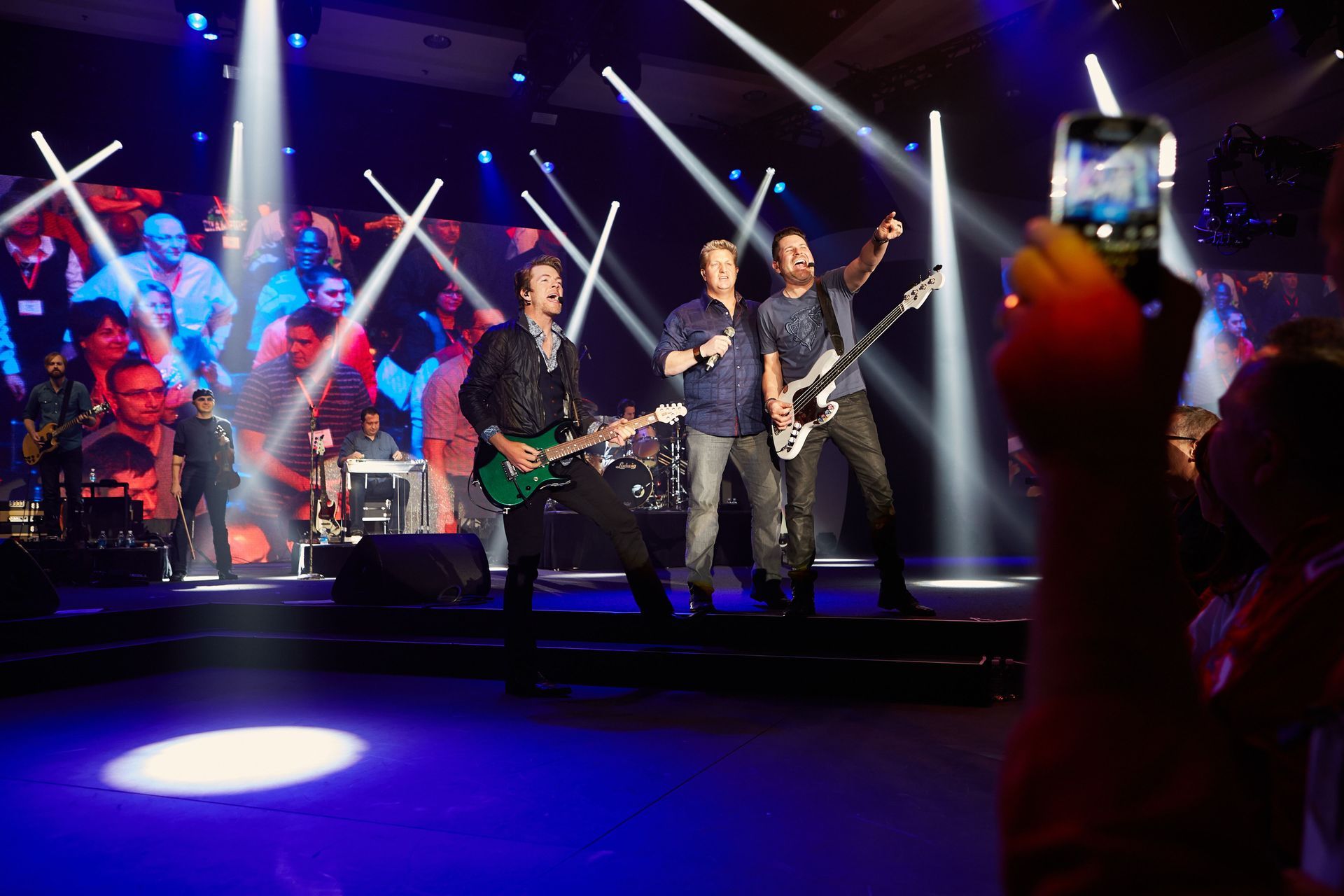 A man is taking a picture of a band on stage.