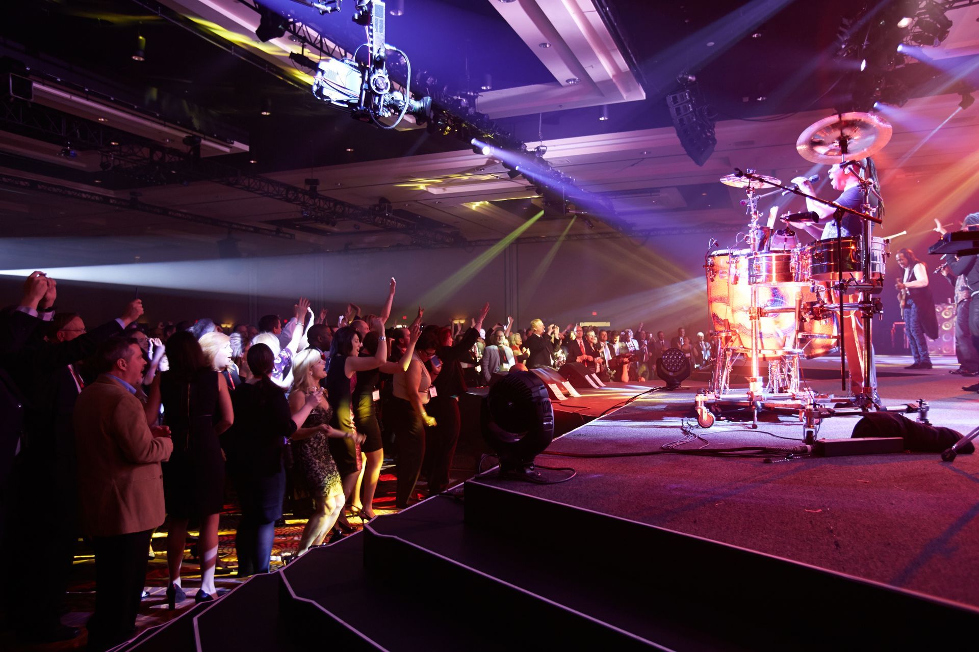 A group of people standing in front of a drum set on a stage