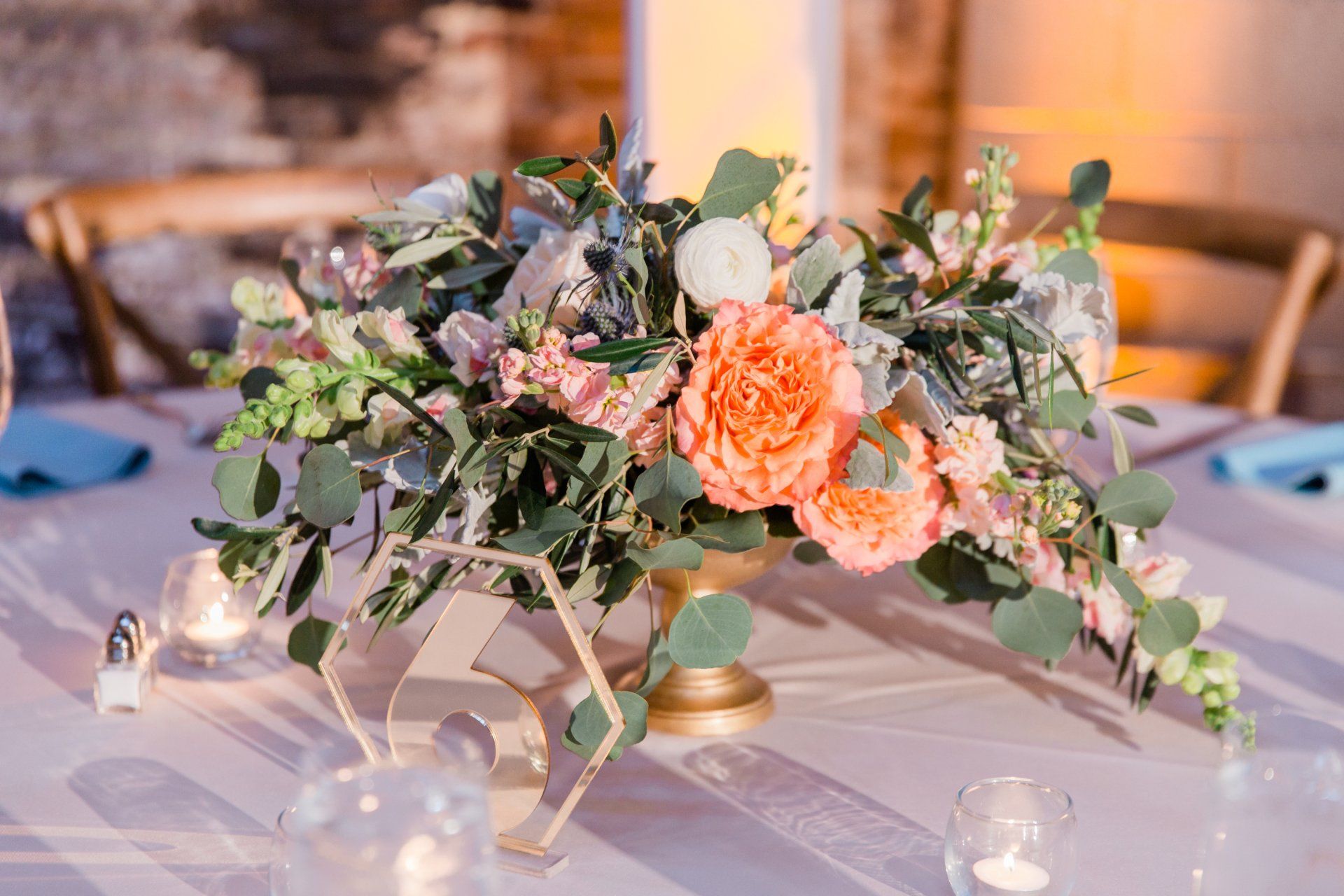 A table with a vase of flowers and candles on it.