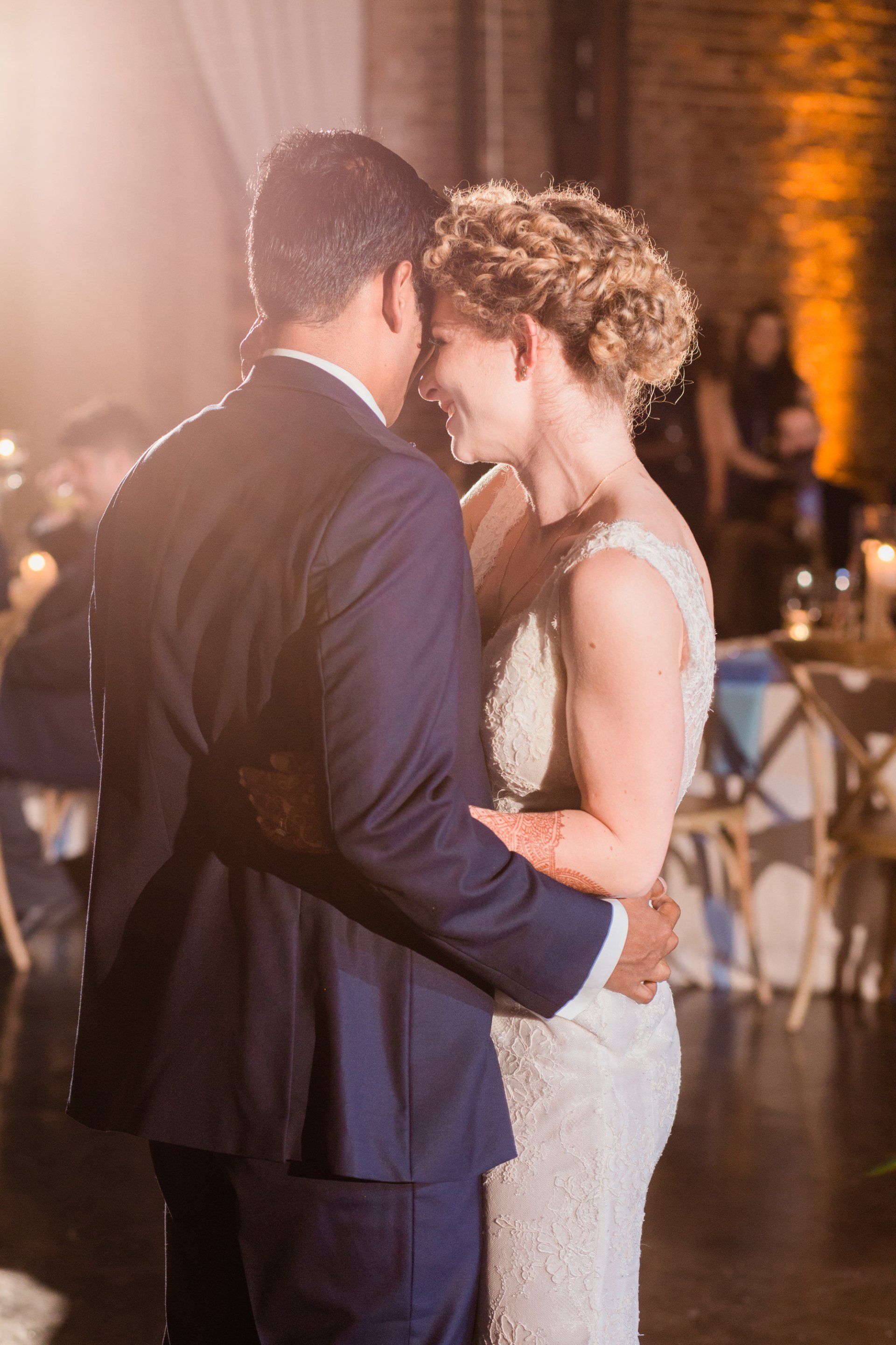 A bride and groom are dancing together at their wedding reception.