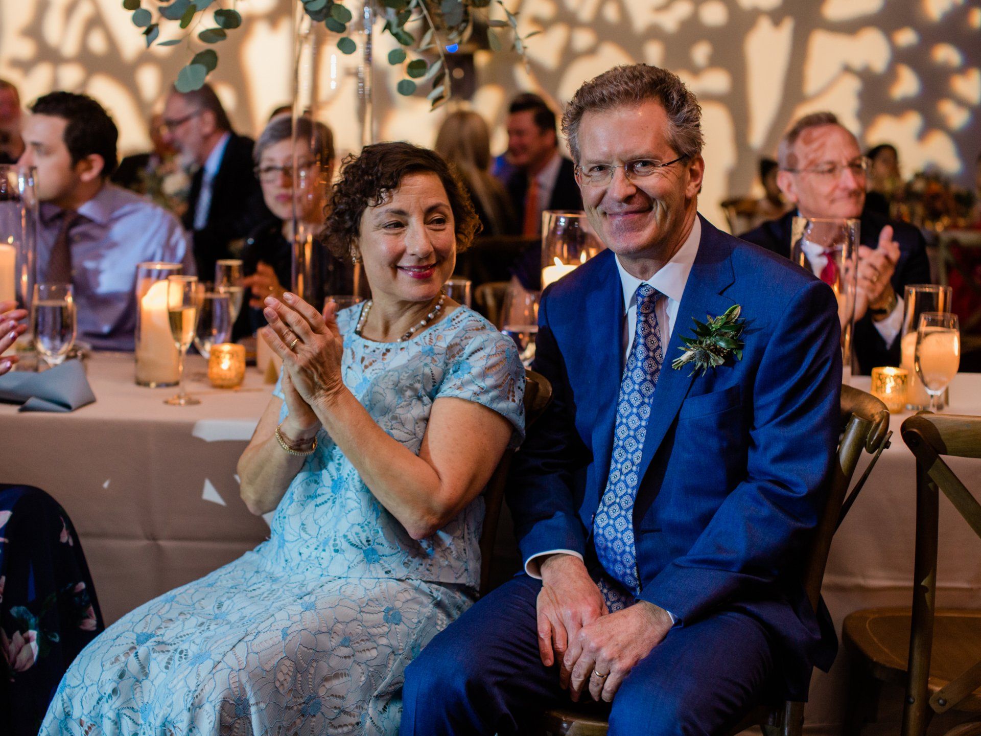A man and a woman are sitting at a table at a wedding reception.