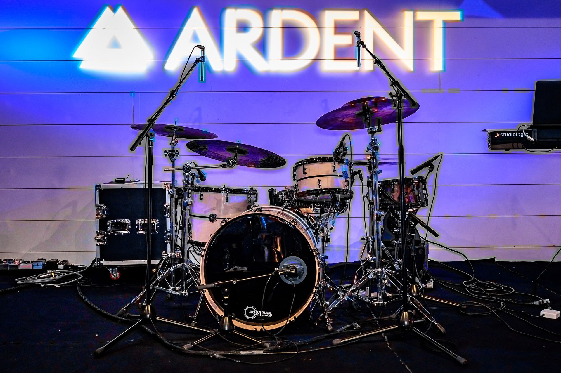 A drum set in front of a sign that says ardent