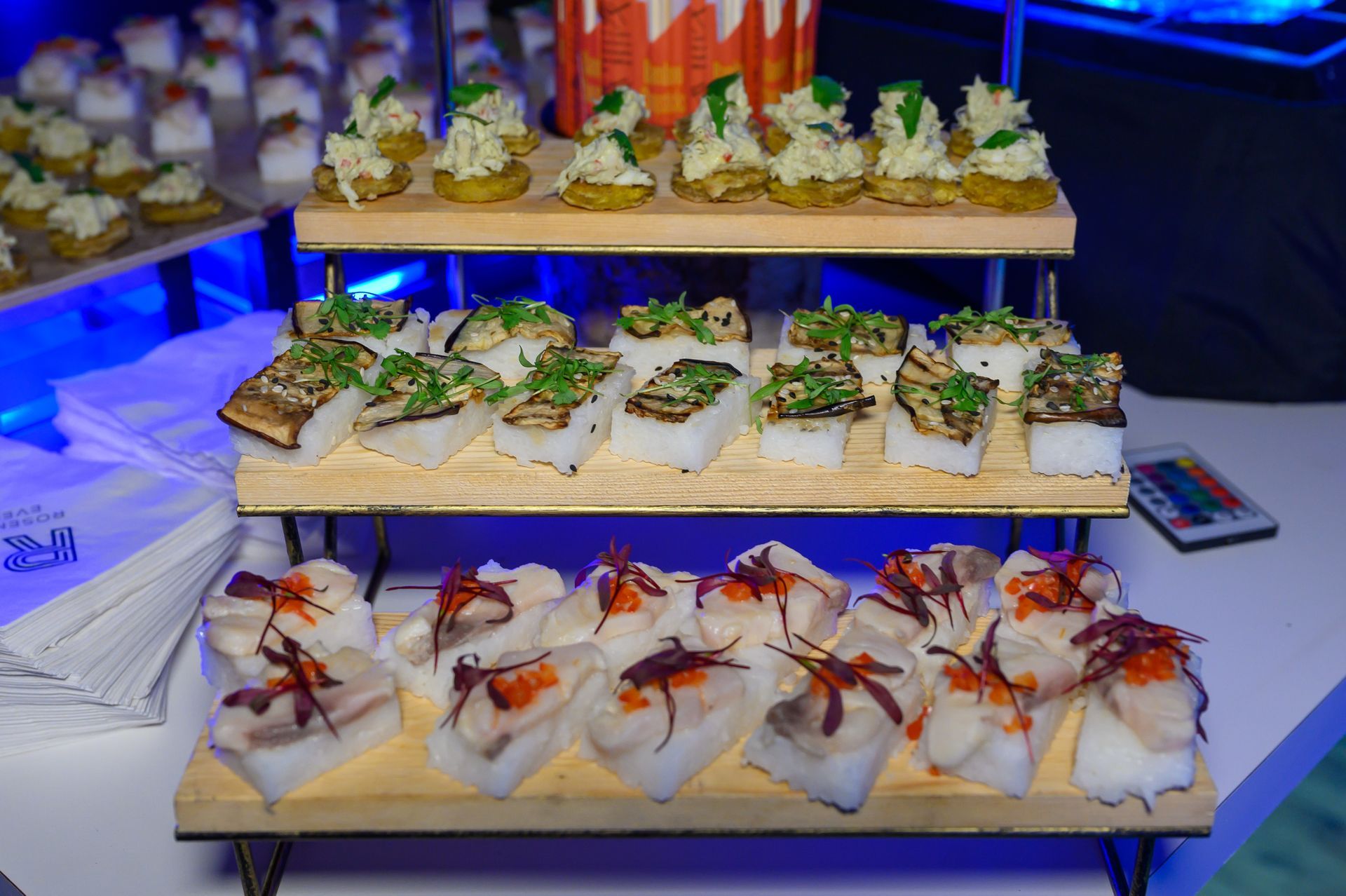 A stack of wooden trays filled with different types of food.