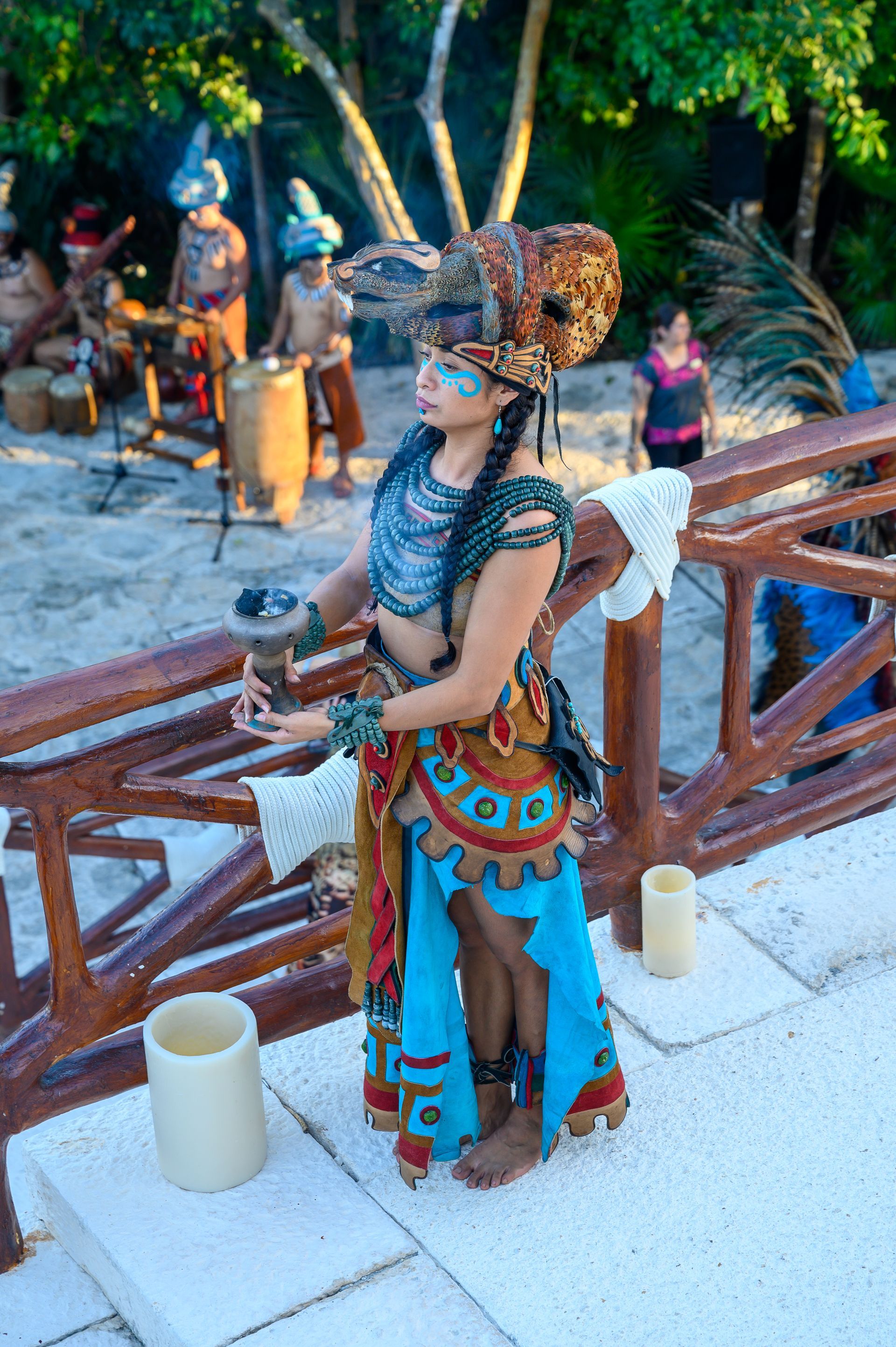 A woman in a costume is standing on a bridge next to candles.
