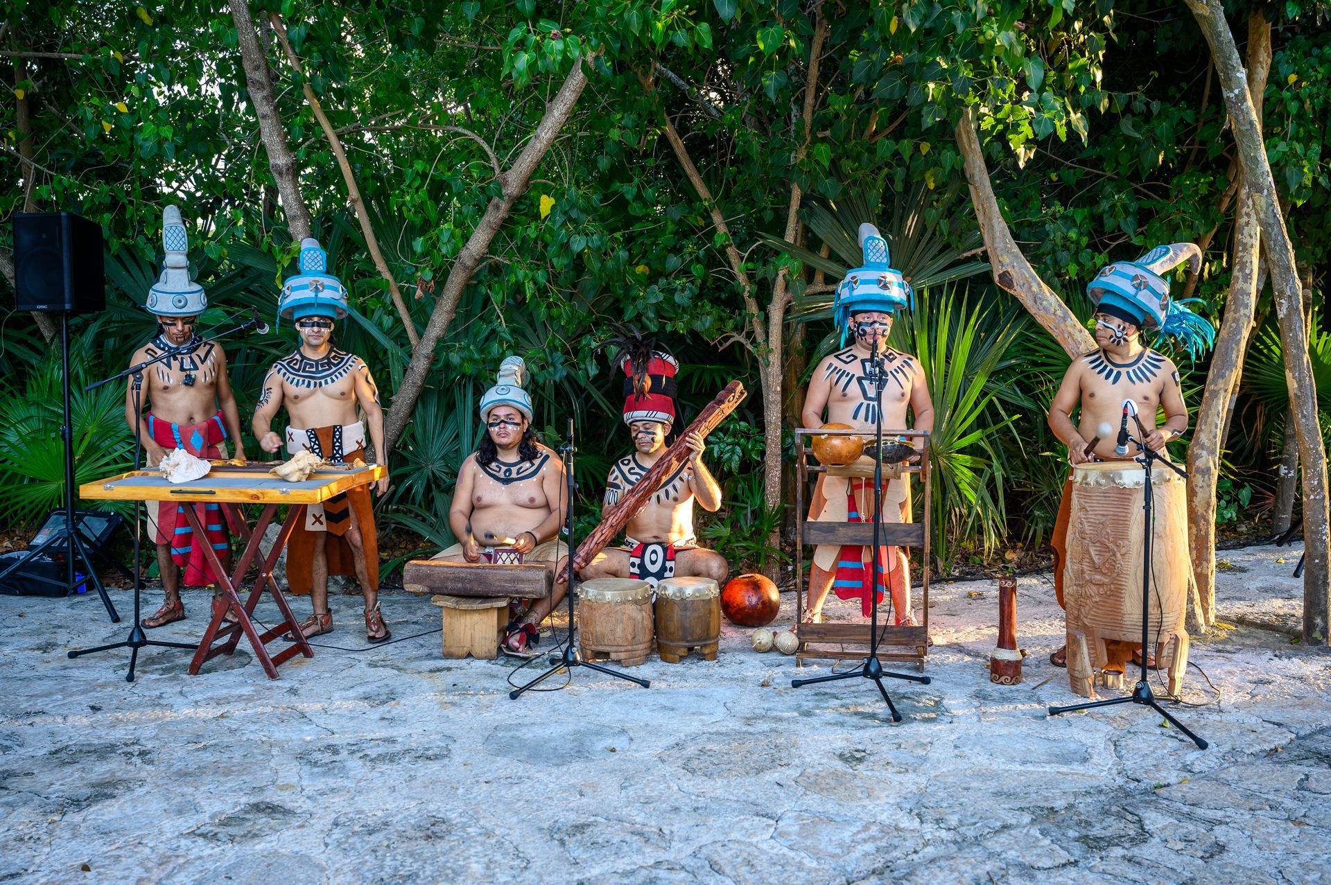 A group of men are playing instruments on a beach as part of an experience.