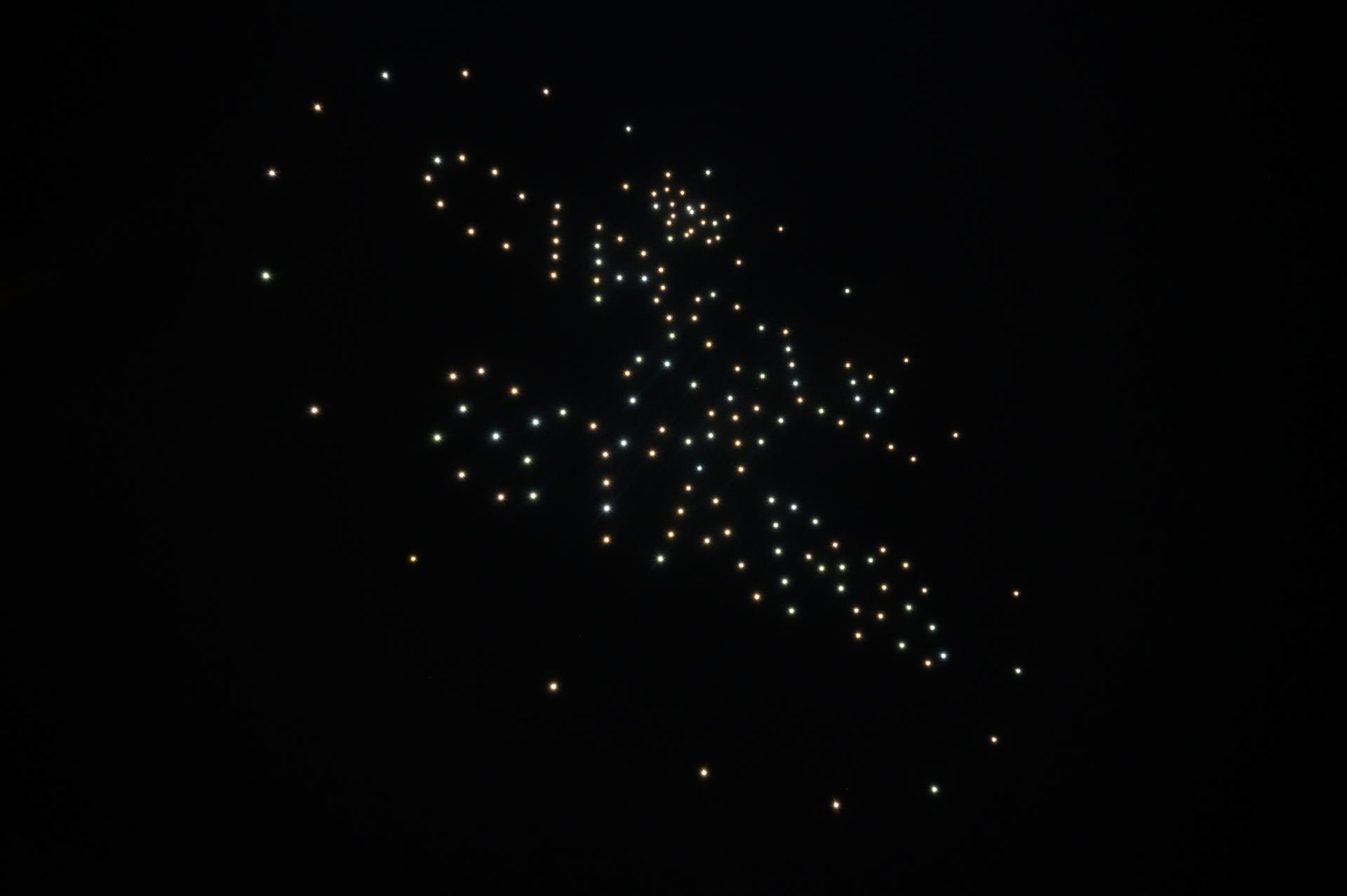 A bunch of lights are flying in the night sky.
