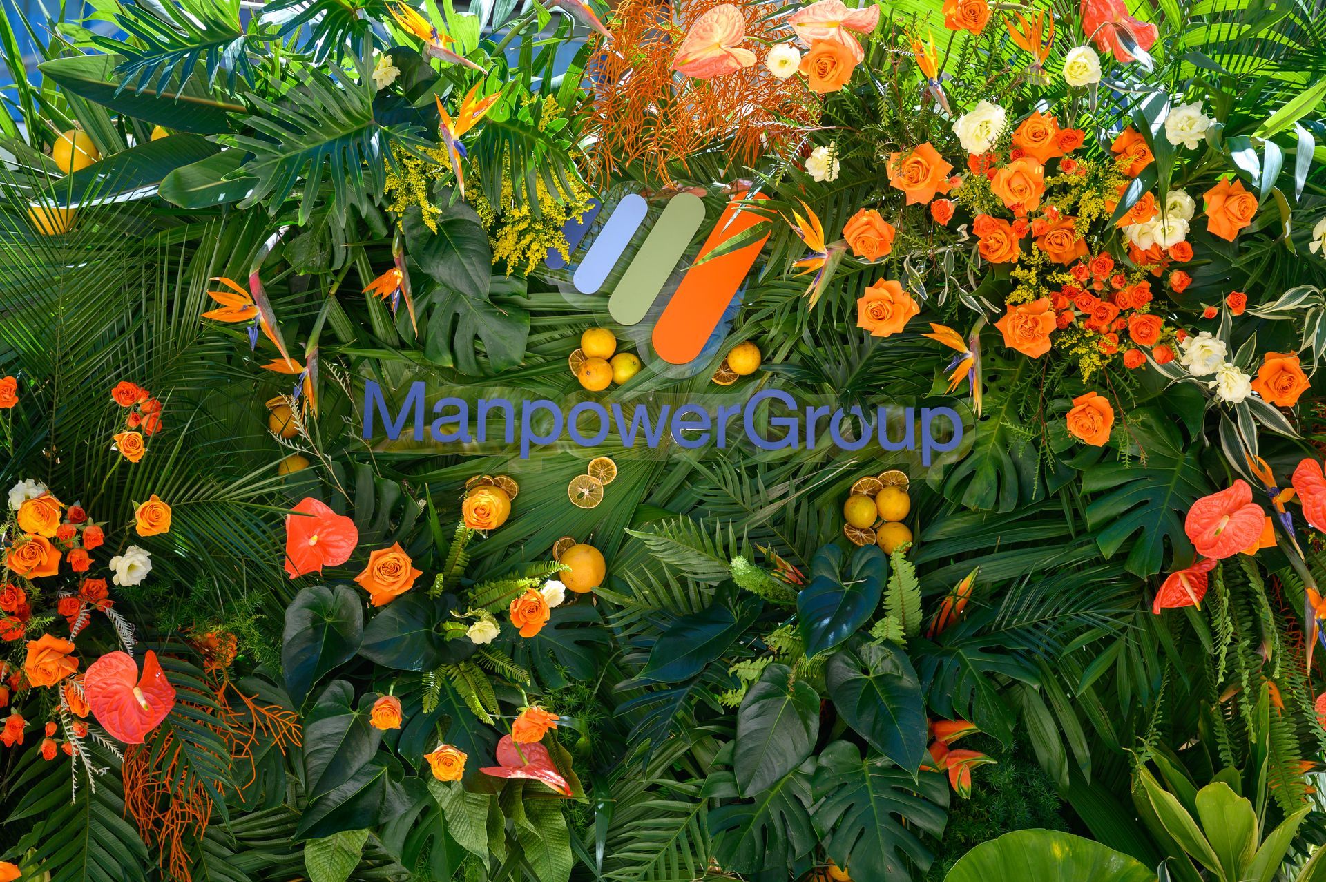 A wall of flowers and leaves with the words manpower group on it