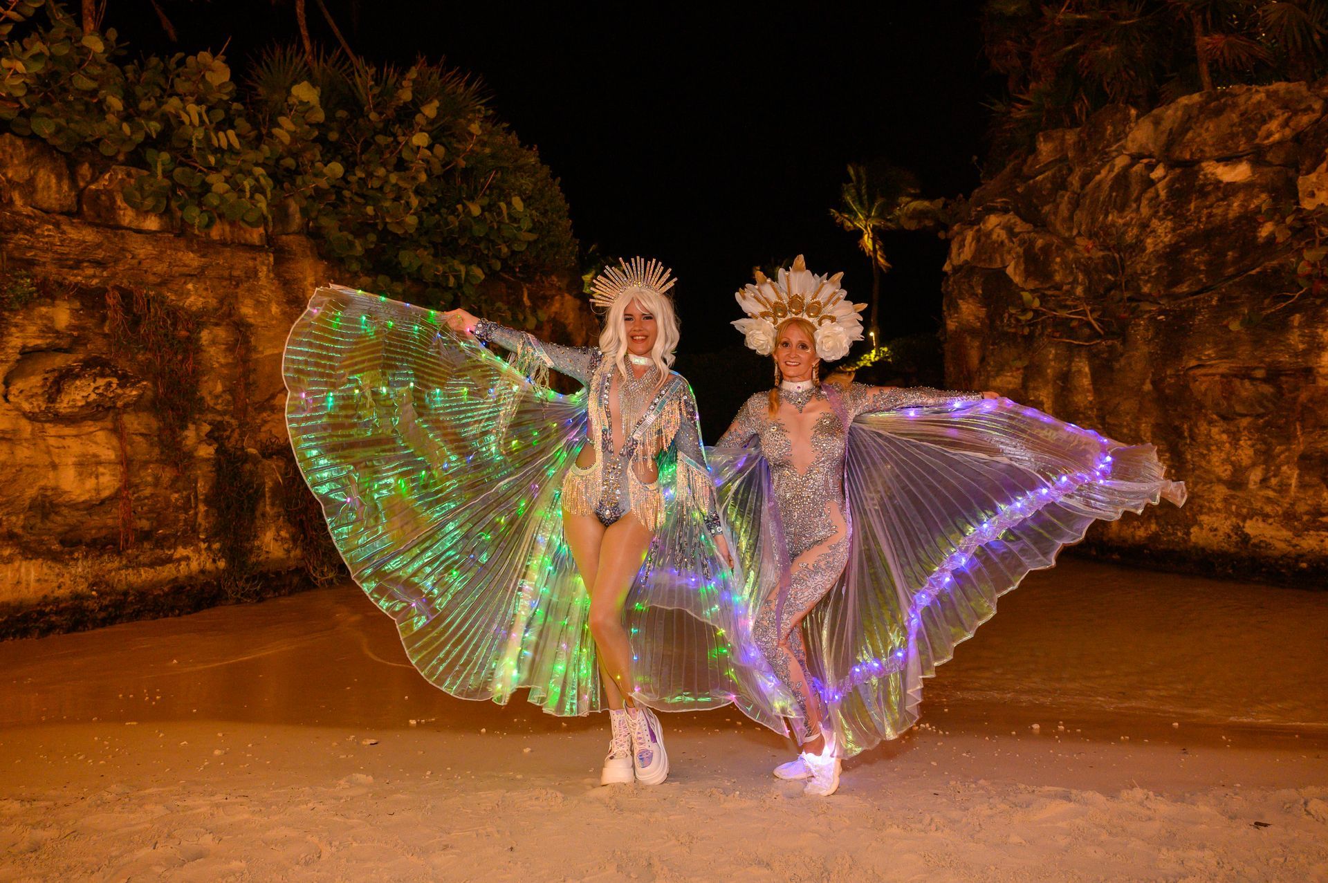 Two women are standing next to each other wearing glow in the dark costumes.