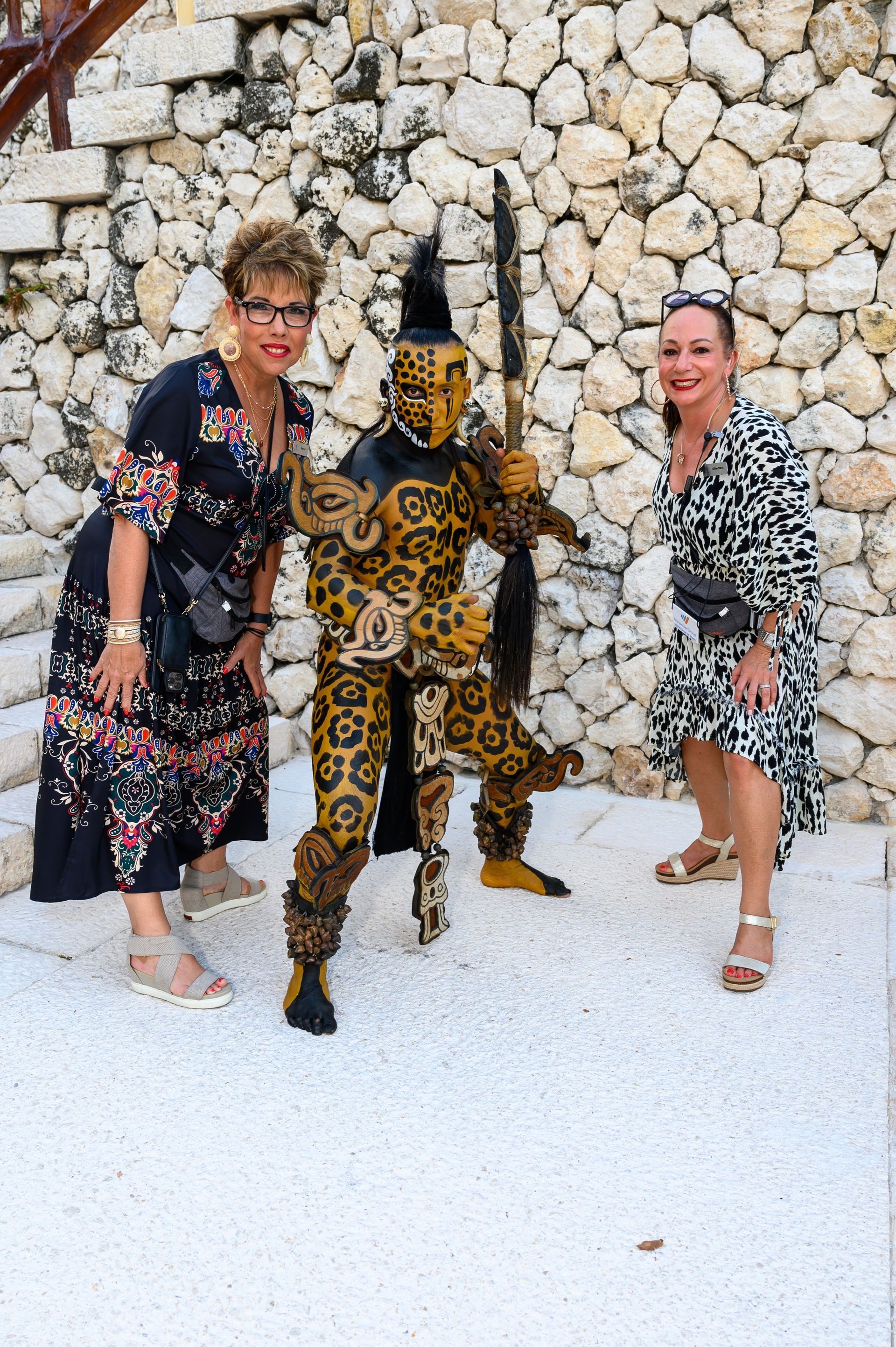 Two women are posing for a picture with a man in a leopard costume