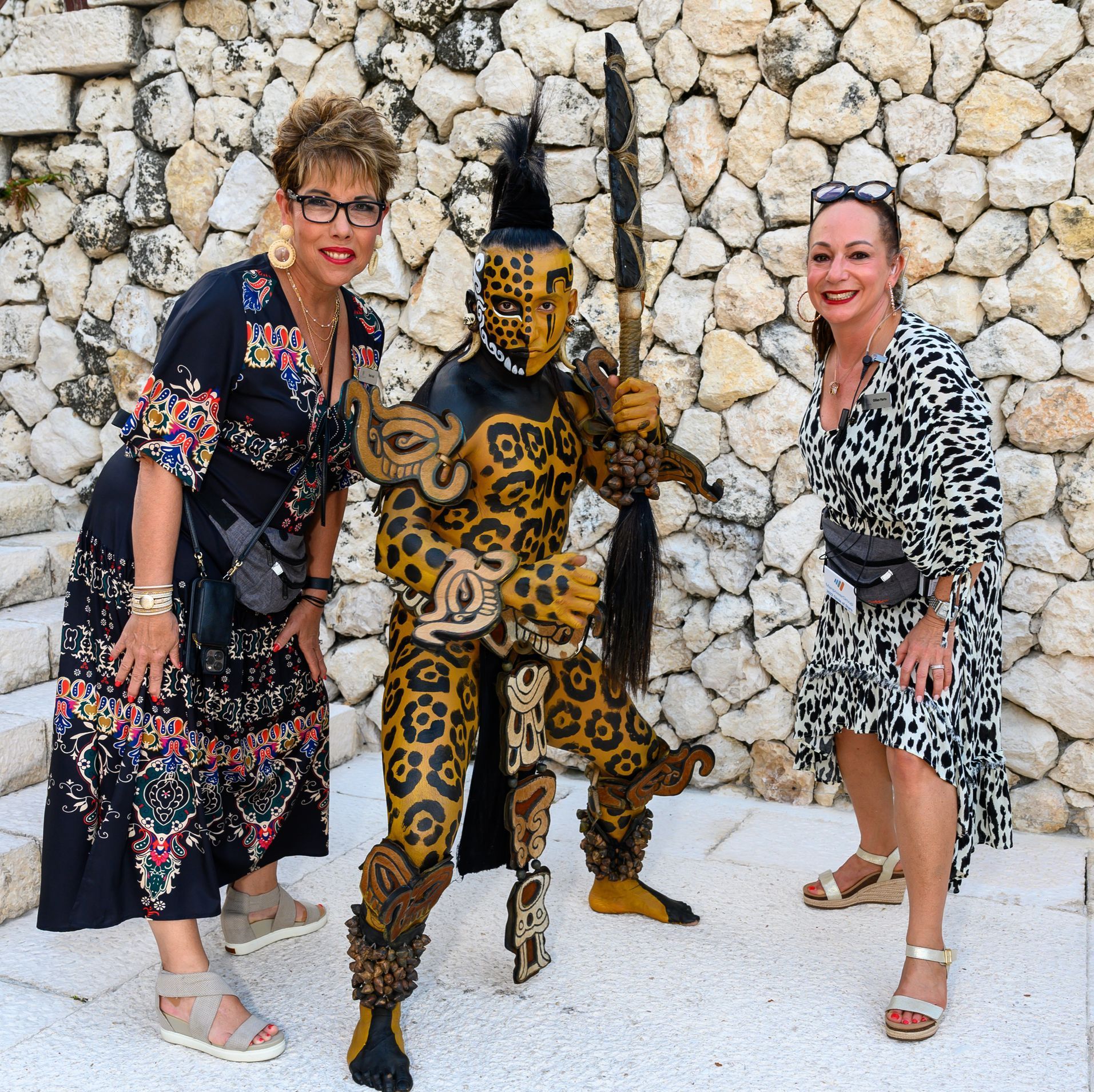 Two women are posing for a picture with a man in a leopard costume