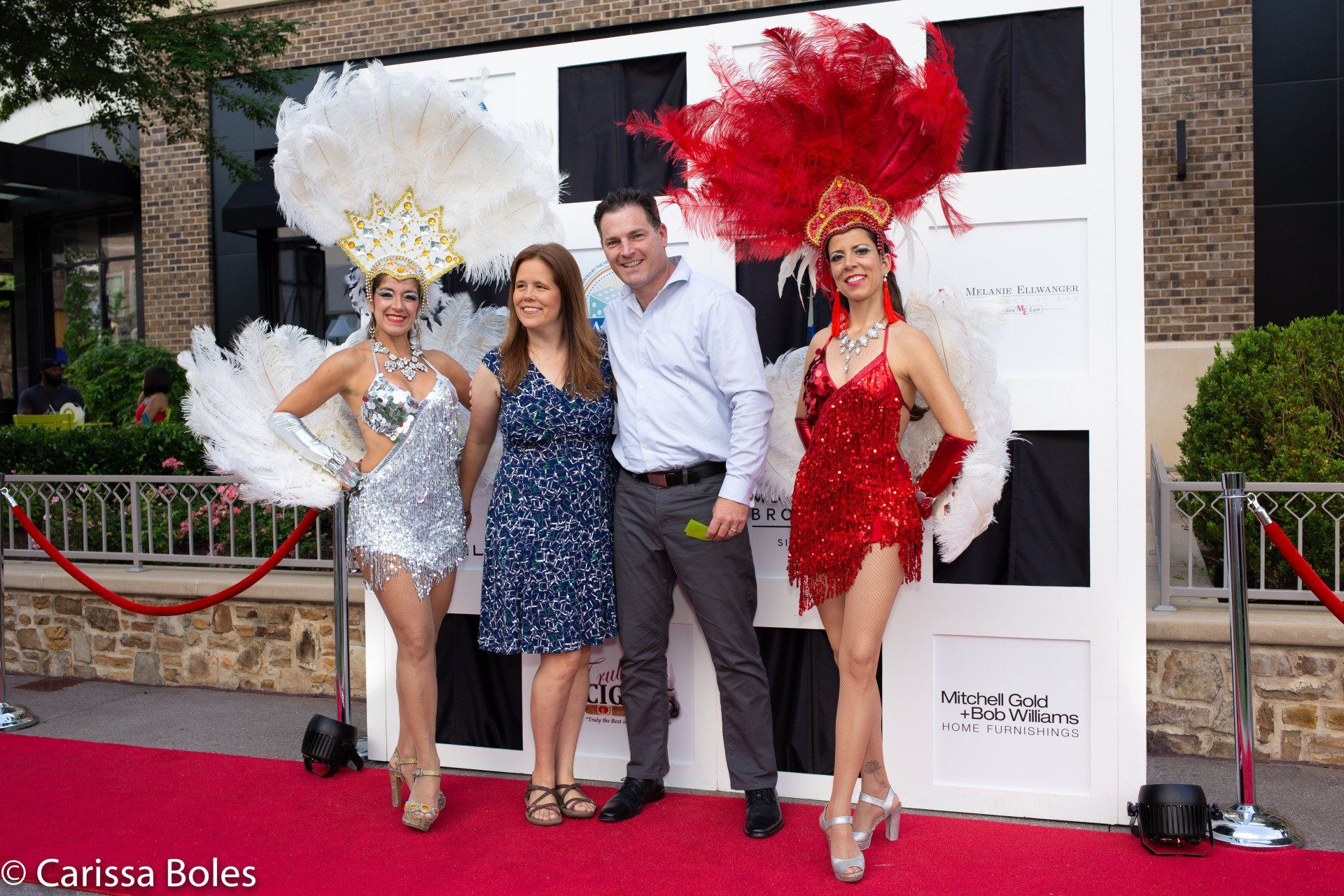 A group of people are posing for a picture on a red carpet.
