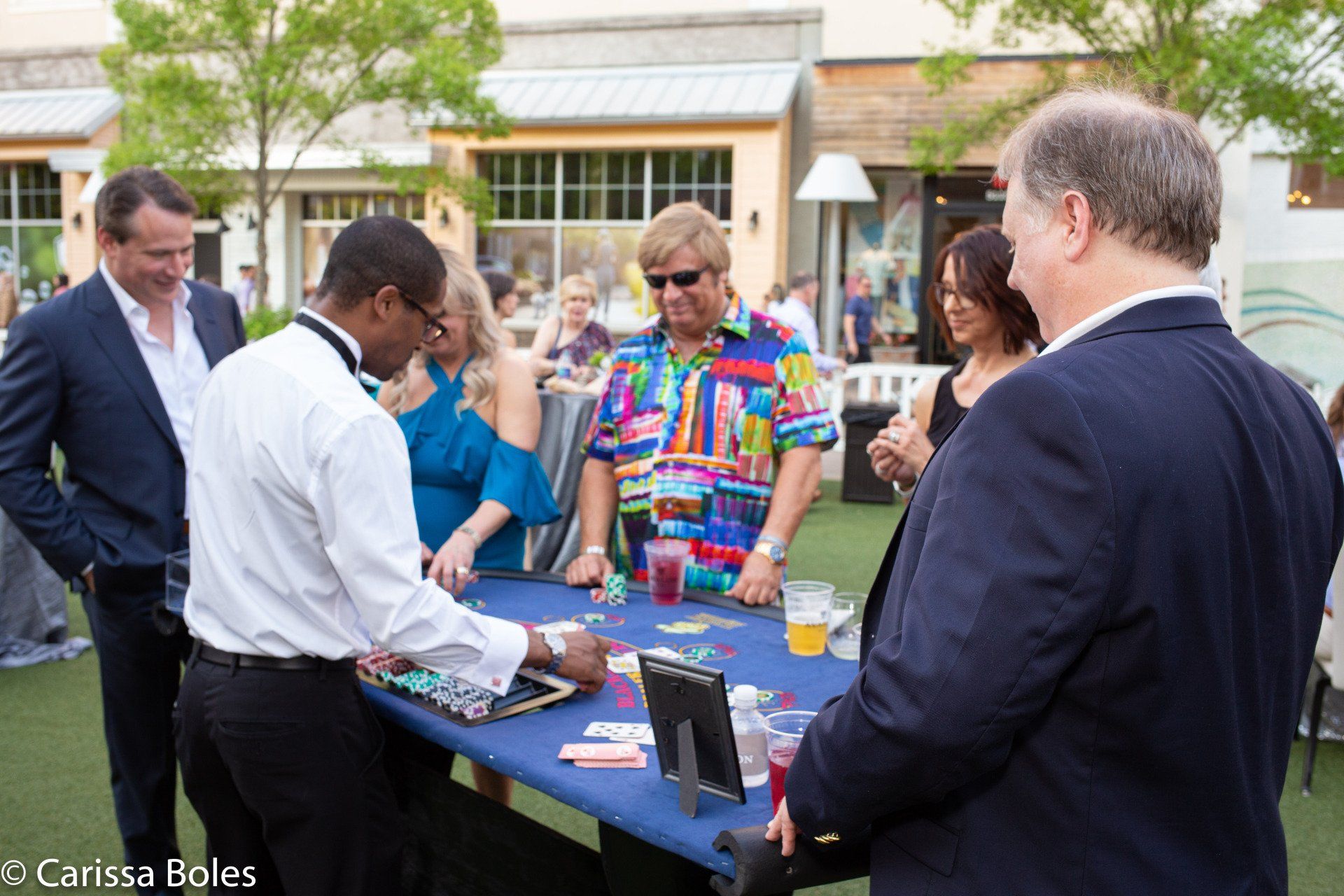 A group of people are playing a game of cards at a table.