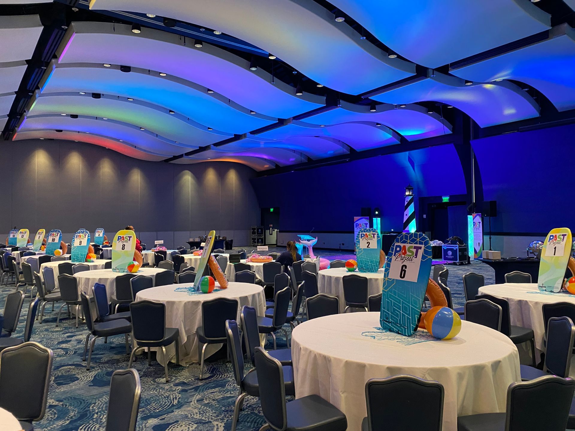 A large room with tables and chairs set up for a party.