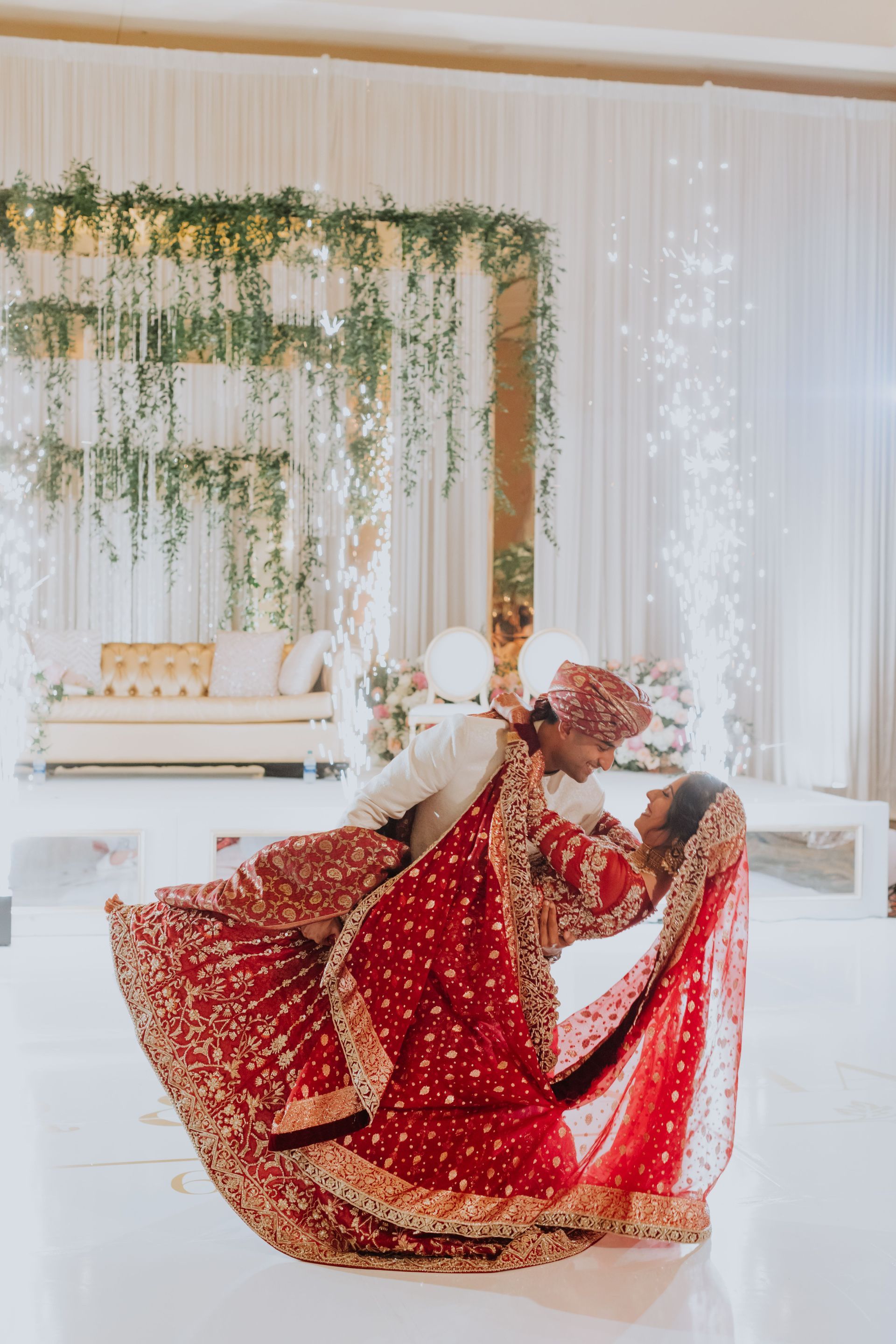 A bride and groom are dancing on a stage at their wedding reception.