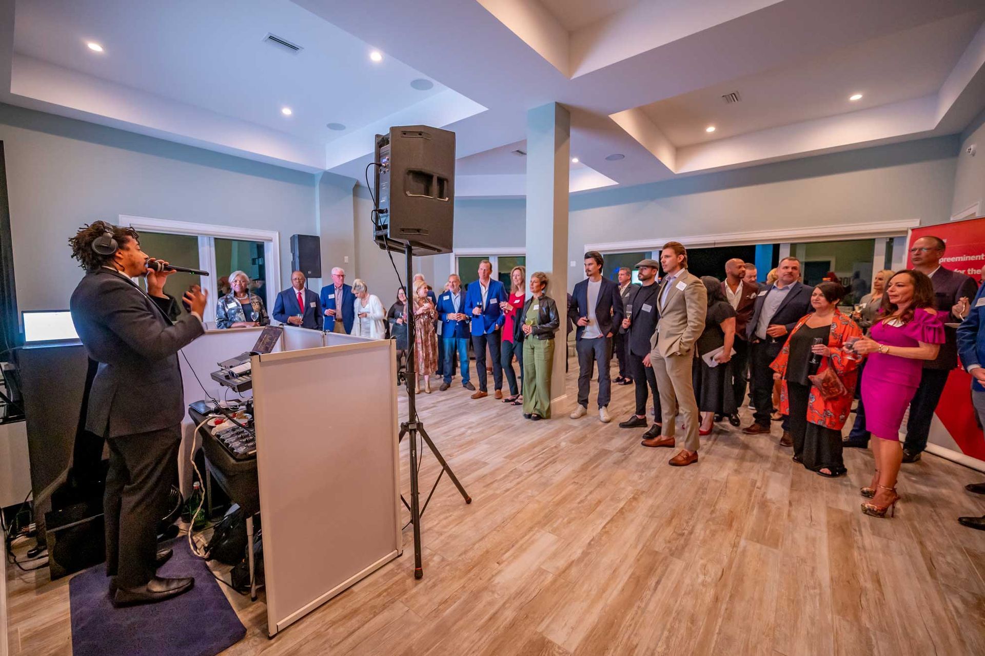 A man is standing in front of a group of people in a room.