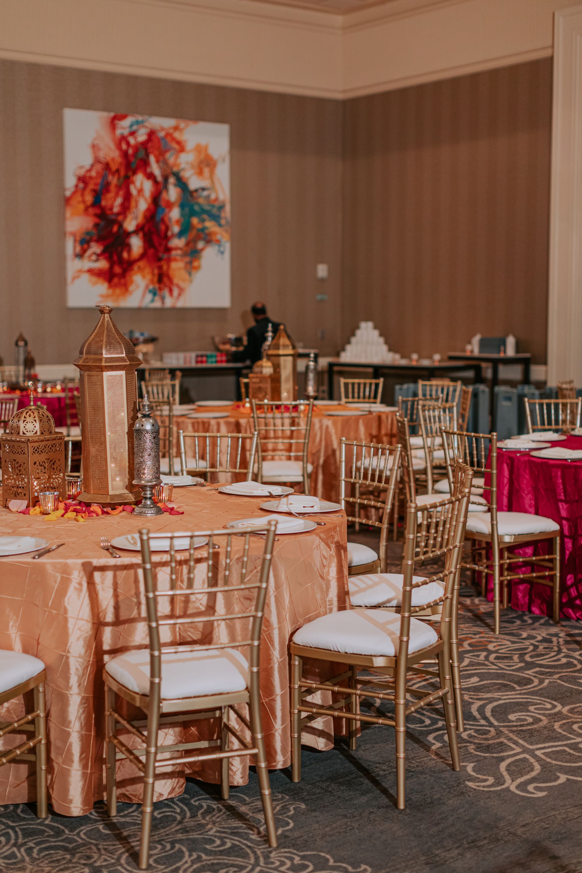 A room with tables and chairs set up for a wedding reception.