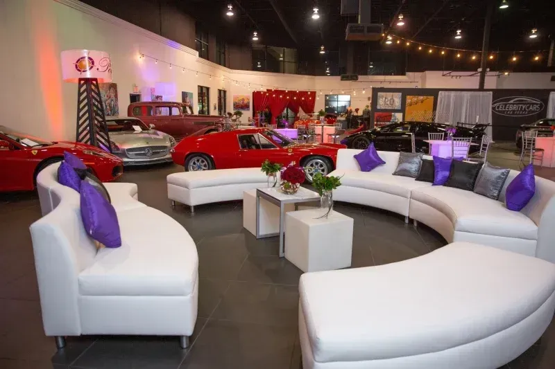 A room with a lot of furniture and cars in the background