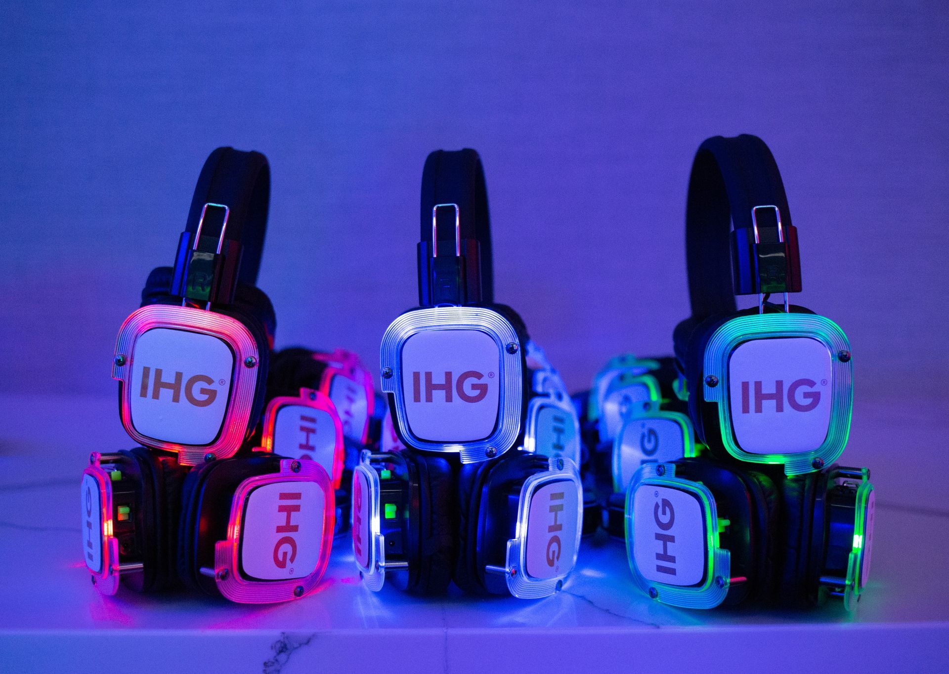 Three pairs of headphones with ihg written on them are sitting on a table.