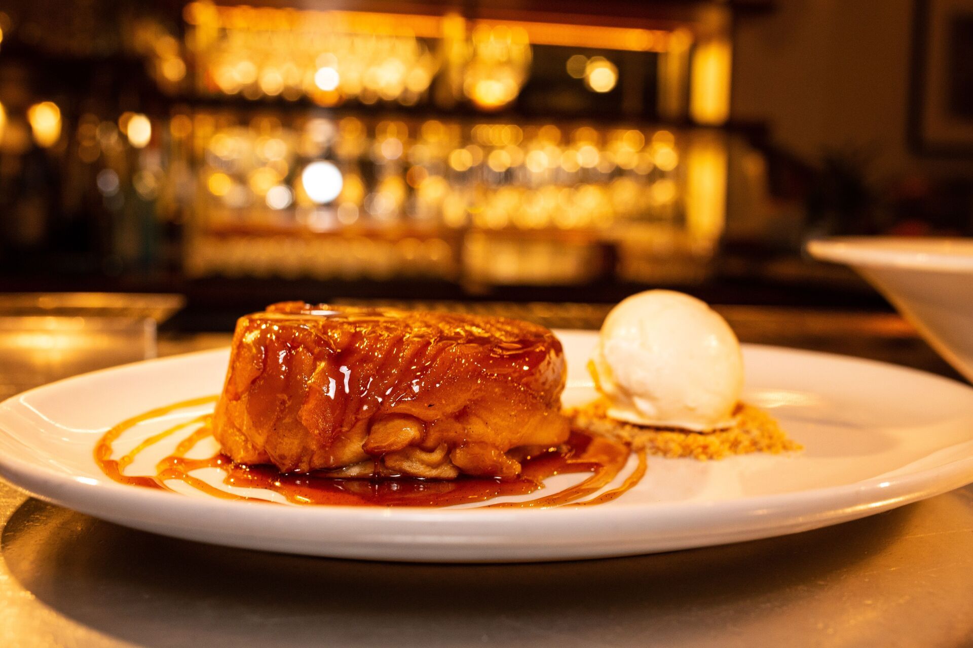 A close up of a plate of food with ice cream on a table.