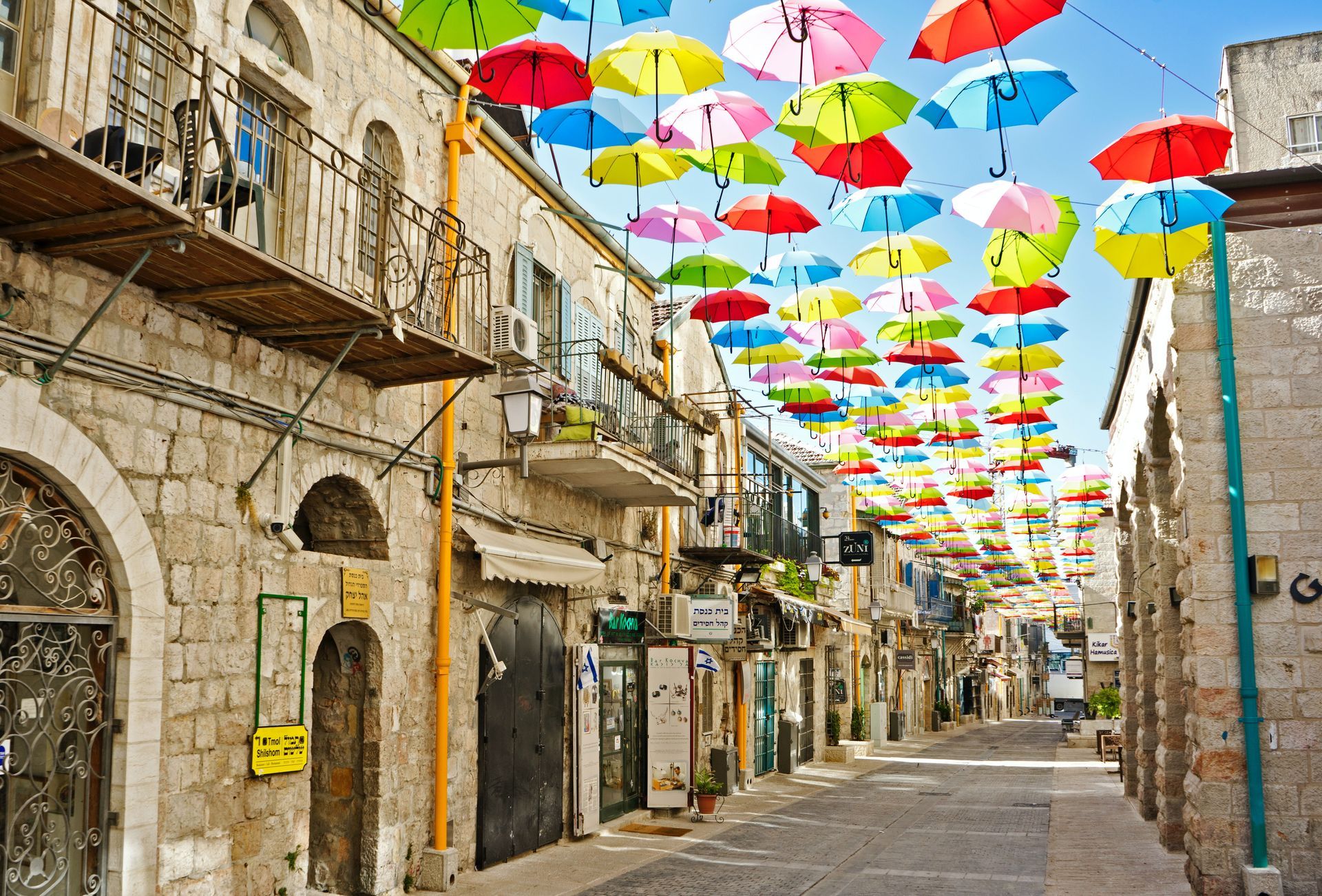 a row of colorful umbrellas hanging over a street