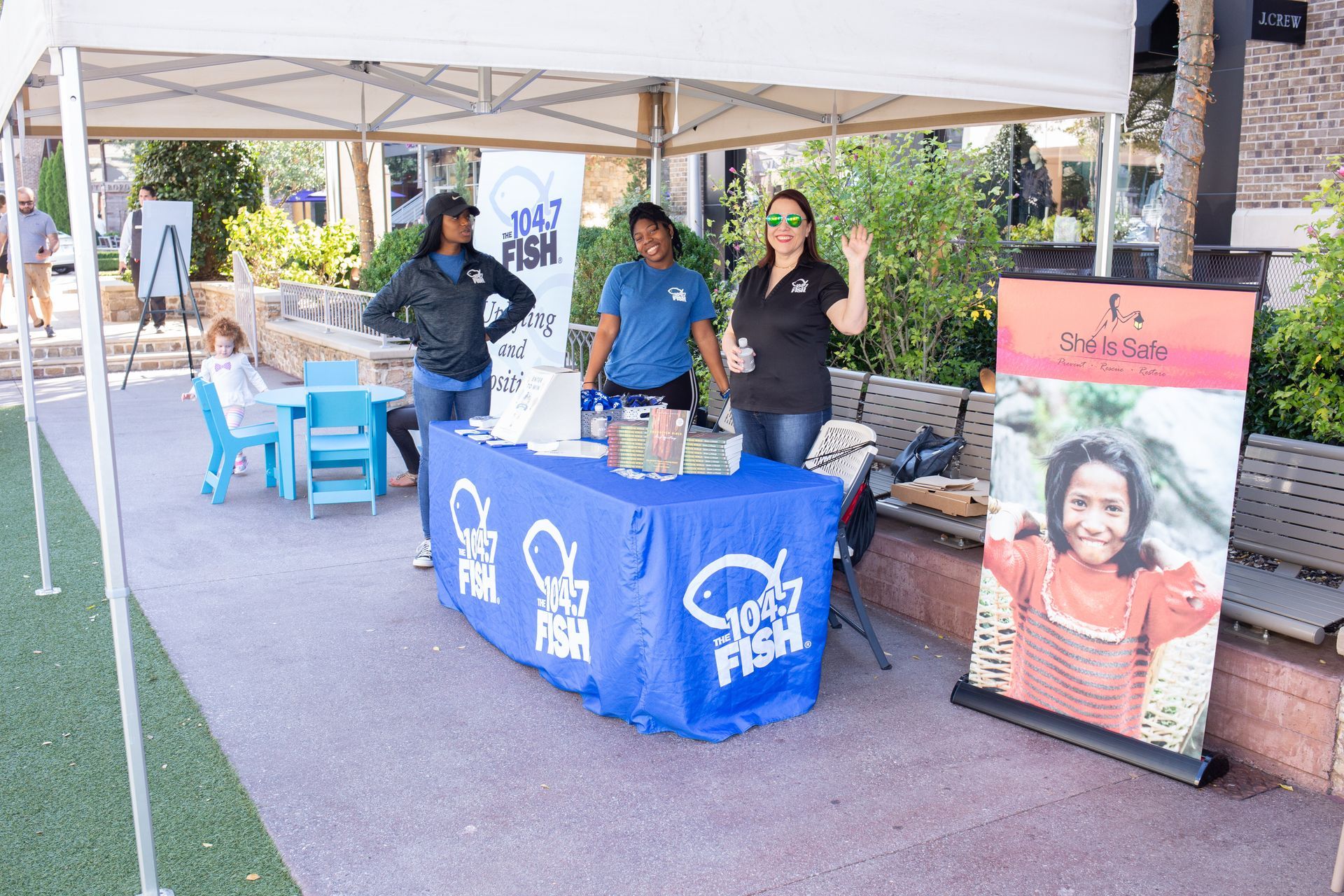 A group of people standing around a table under a tent.